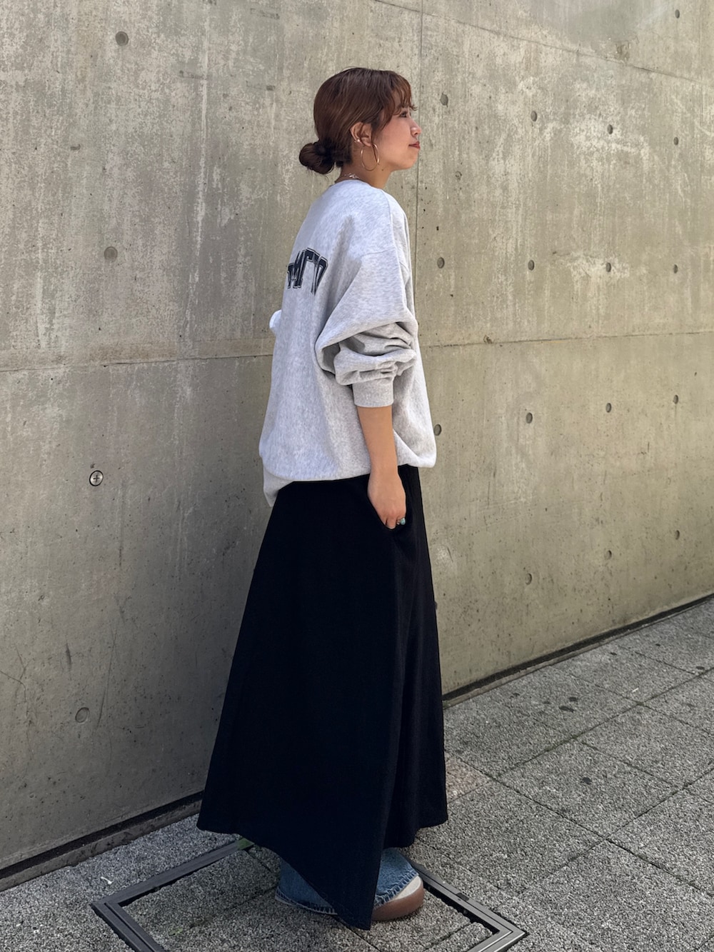 ブルー系のデニムパンツ、ブラック系のワンピース、グレー系のスウェットを着用したレディースの夏コーディネートの3枚目の写真