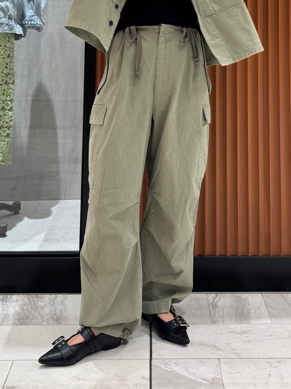 グリーン系のミリタリージャケット、ブラック系のキャミソール、グリーン系のその他パンツを着用したレディースの春コーディネートの5枚目の写真