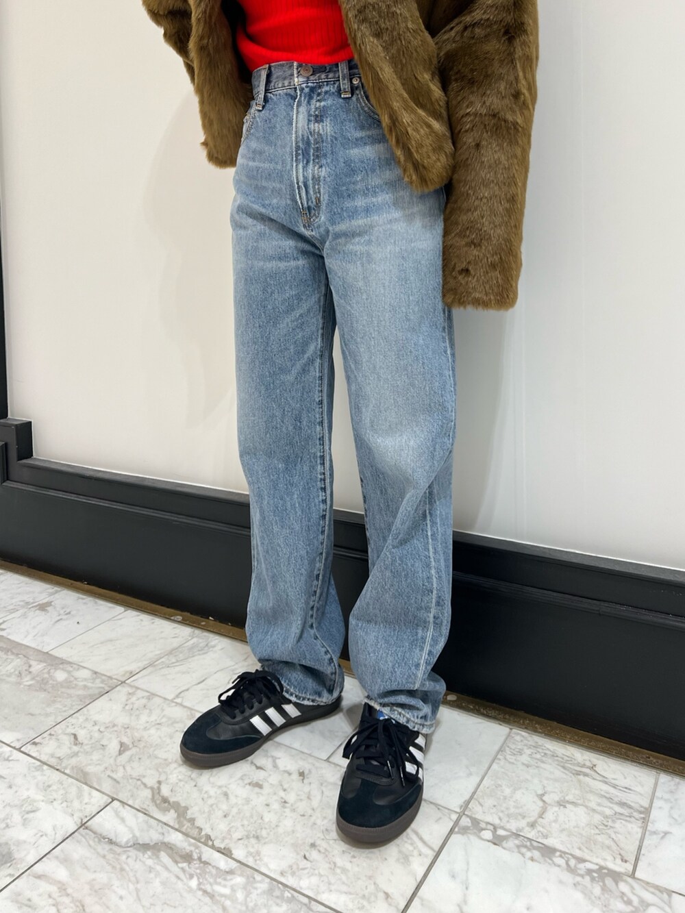 ブルー系のデニムパンツ、ブラウン系のブルゾン、レッド系のニット/セーターを着用したレディースの冬コーディネートの8枚目の写真