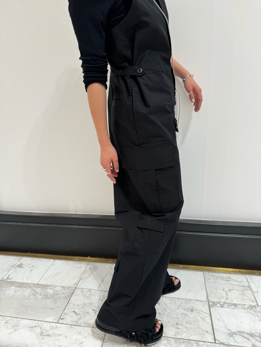 ブラック系のつなぎ/オールインワン、ブラック系のTシャツ/カットソー、ブラック系のサンダルを着用したレディースの冬コーディネートの4枚目の写真