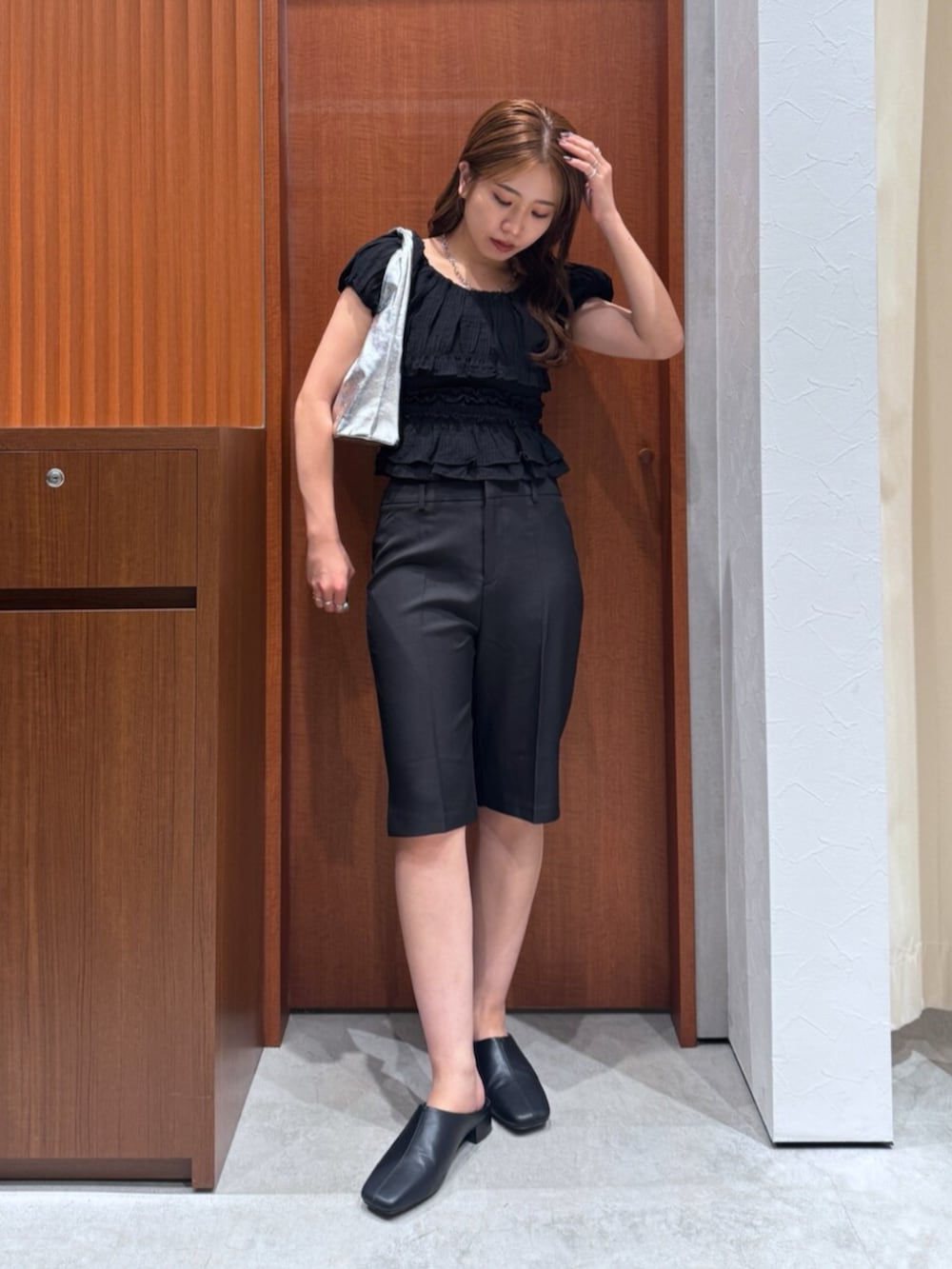 シルバー系のハンドバッグ、ブラック系のサンダル、ブラック系のその他パンツを着用したレディースの夏コーディネートの2枚目の写真