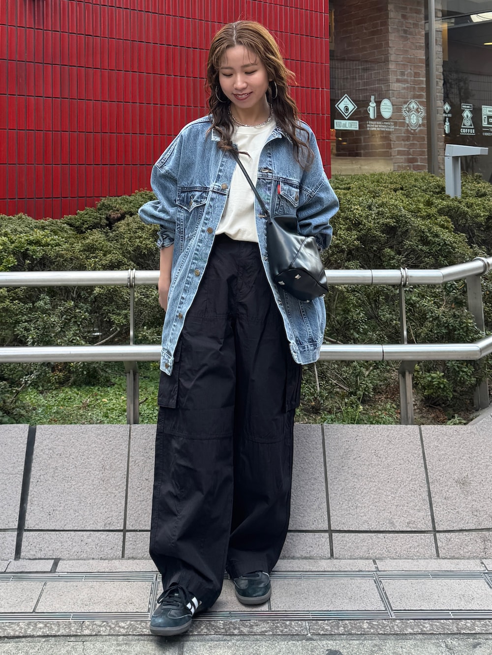 ブラック系のその他パンツ、ブルー系のデニムジャケット、ホワイト系のTシャツ/カットソーを着用したレディースの冬コーディネートの2枚目の写真