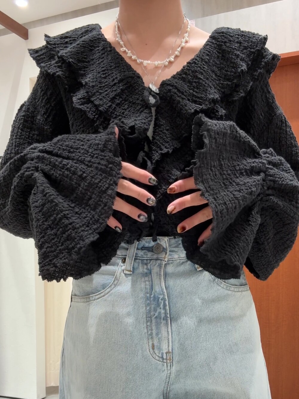 ブラック系のシャツ/ブラウス、ブルー系のデニムパンツを着用したレディースの春コーディネートの7枚目の写真