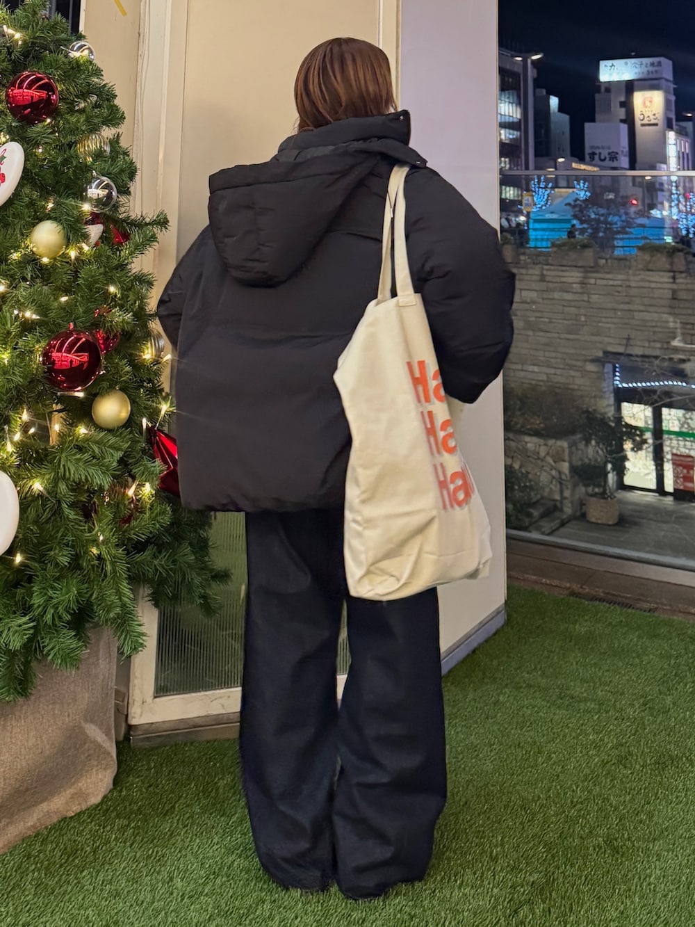 グレー系のカーディガン/ボレロ、ブラック系のダウンジャケット/コート、ホワイト系のトートバッグを着用したレディースの冬コーディネートの3枚目の写真