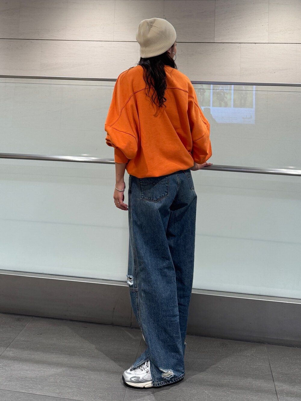 ブルー系のデニムパンツ、オレンジ系のスウェットを着用したレディースの冬コーディネートの10枚目の写真