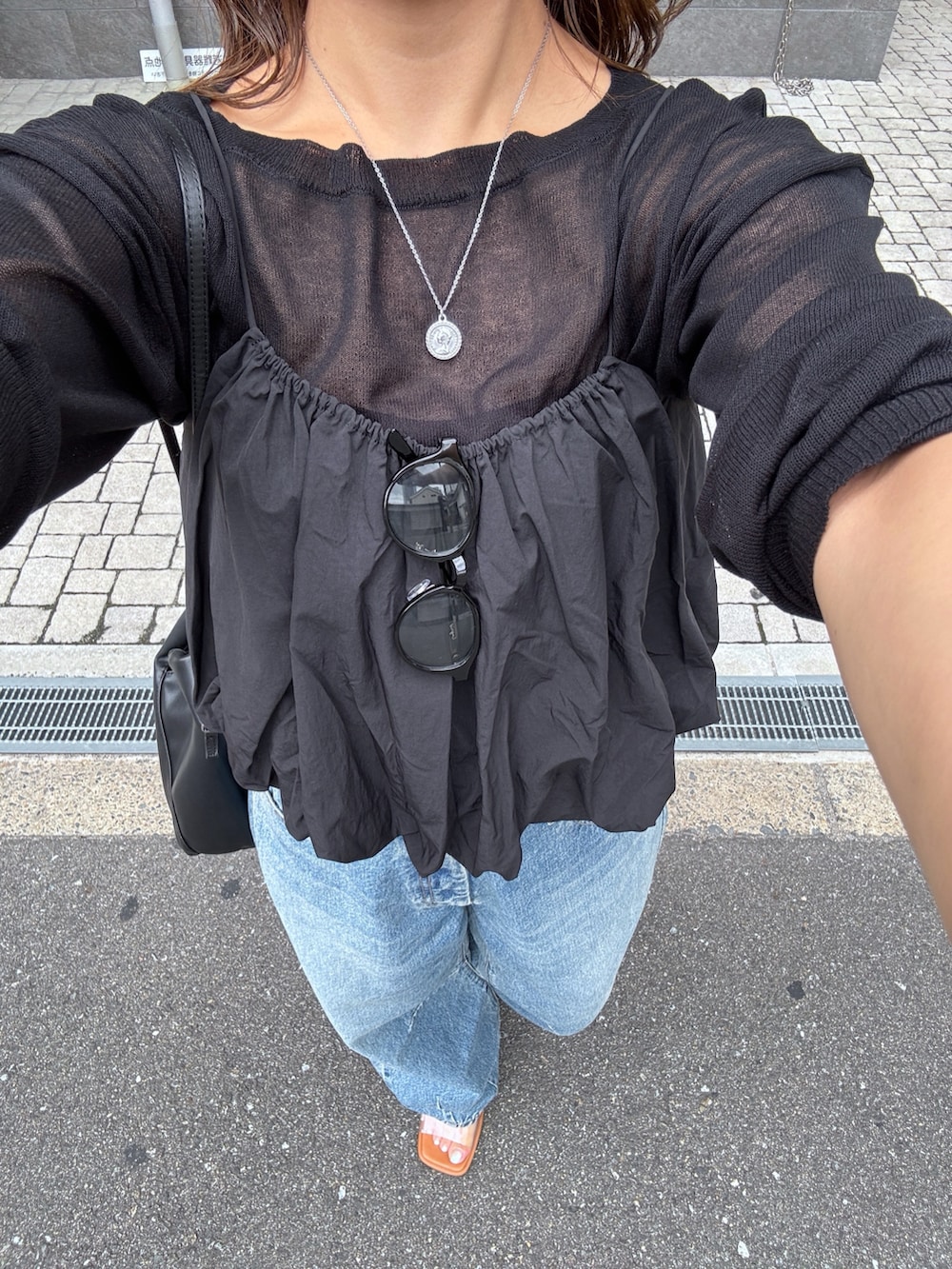 ブルー系のデニムパンツ、ブラック系のキャミソール、ブラック系のニット/セーターを着用したレディースの夏コーディネートの10枚目の写真