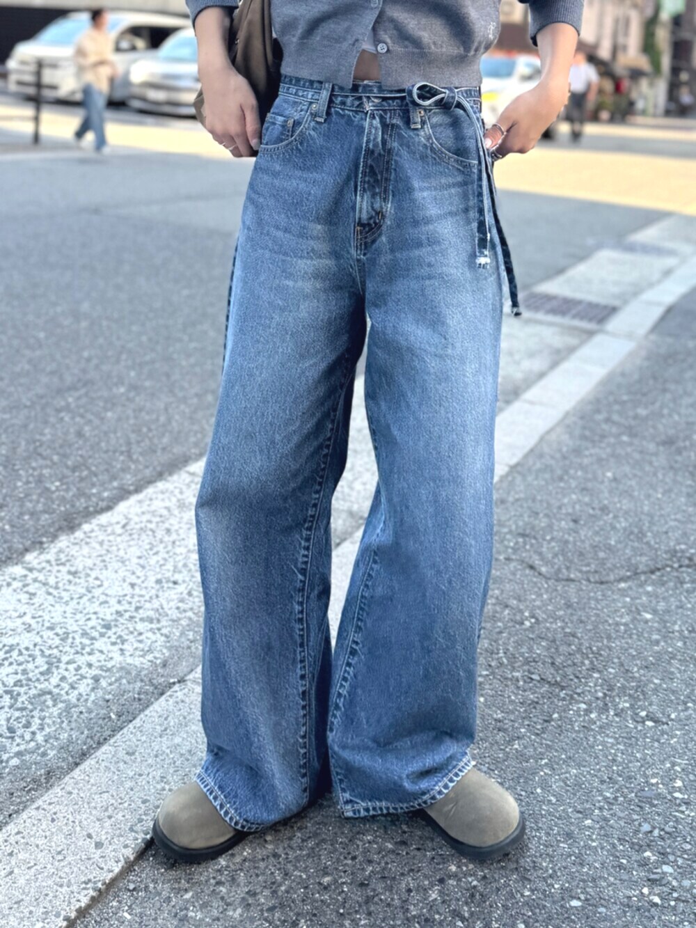 ベージュ系のスリッポン、グレー系のカーディガン/ボレロ、ブルー系のデニムパンツを着用したレディースの夏コーディネートの5枚目の写真