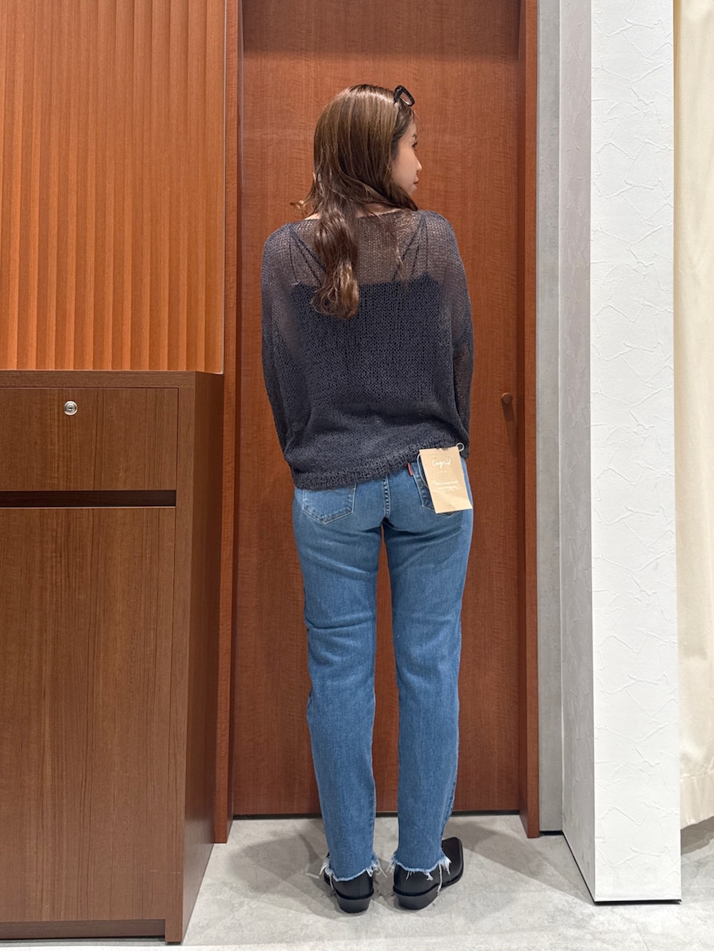 グリーン系のトレンチコート、グレー系のニット/セーター、ブラック系のシャツ/ブラウスを着用したレディースの秋コーディネートの8枚目の写真