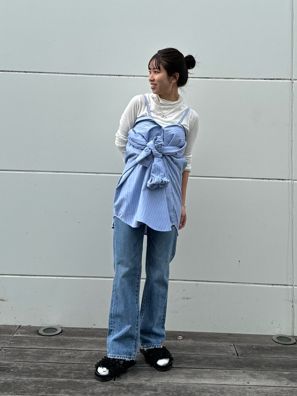 ホワイト系のTシャツ/カットソー、ブルー系のデニムパンツ、ブラック系のショルダーバッグを着用したレディースの冬コーディネートの8枚目の写真