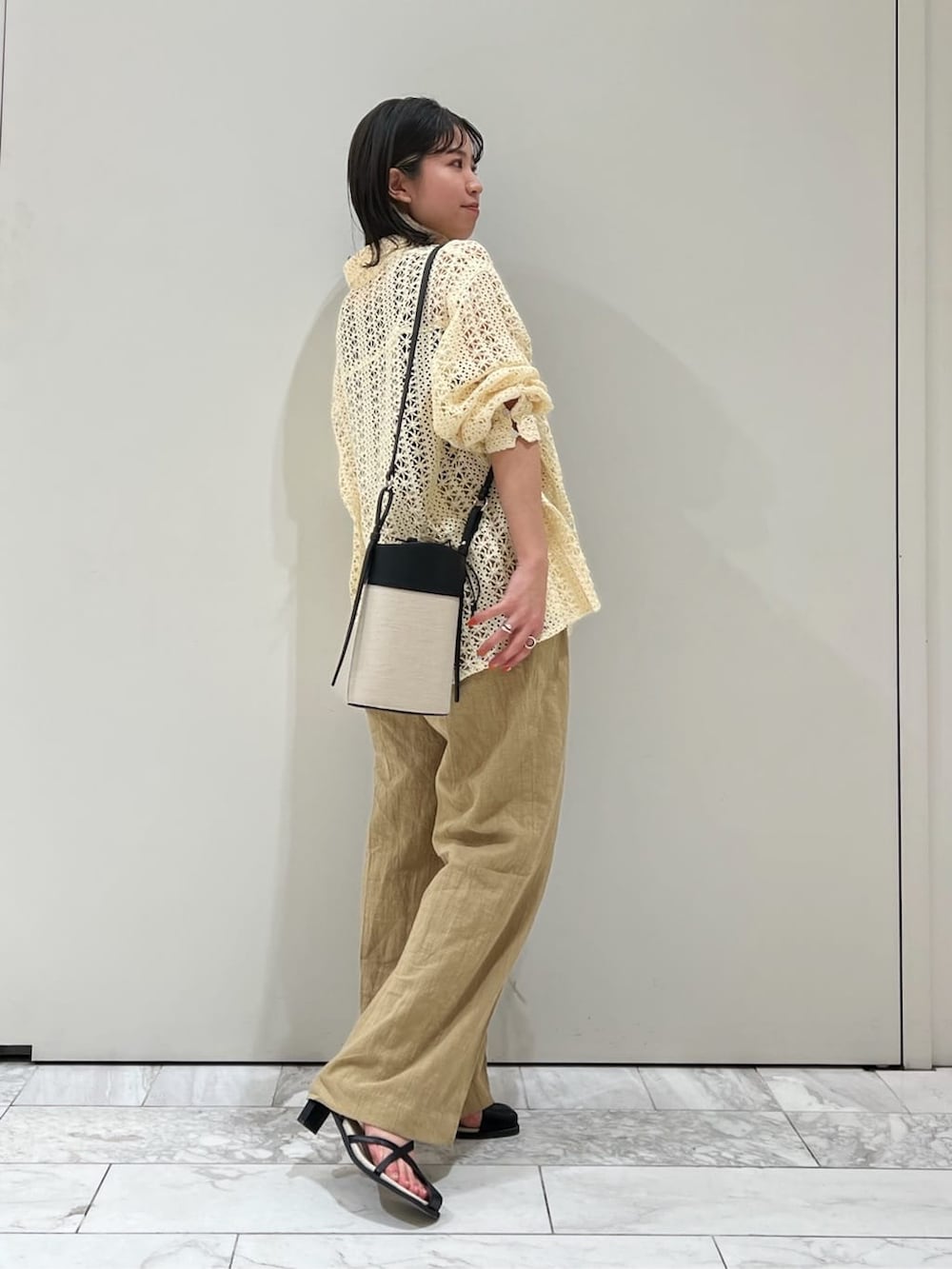 ブラック系のタンクトップ、ブラック系のサンダル、ブラック系のショルダーバッグを着用したレディースの春コーディネートの2枚目の写真