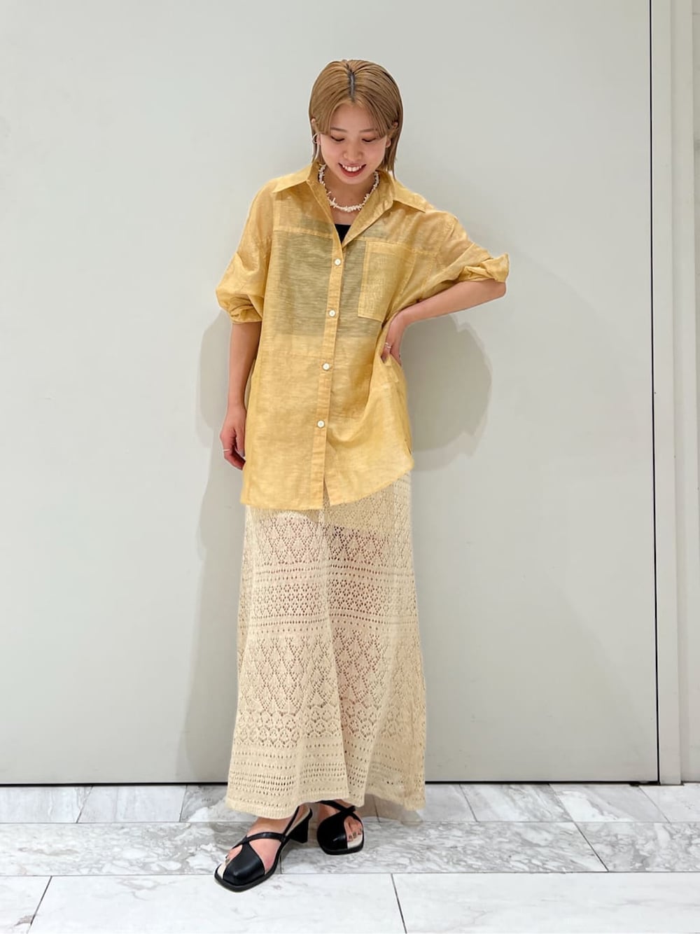 ブラウン系のシャツ/ブラウス、ベージュ系のスカート、ブラック系のサンダルを着用したレディースの春コーディネートの4枚目の写真