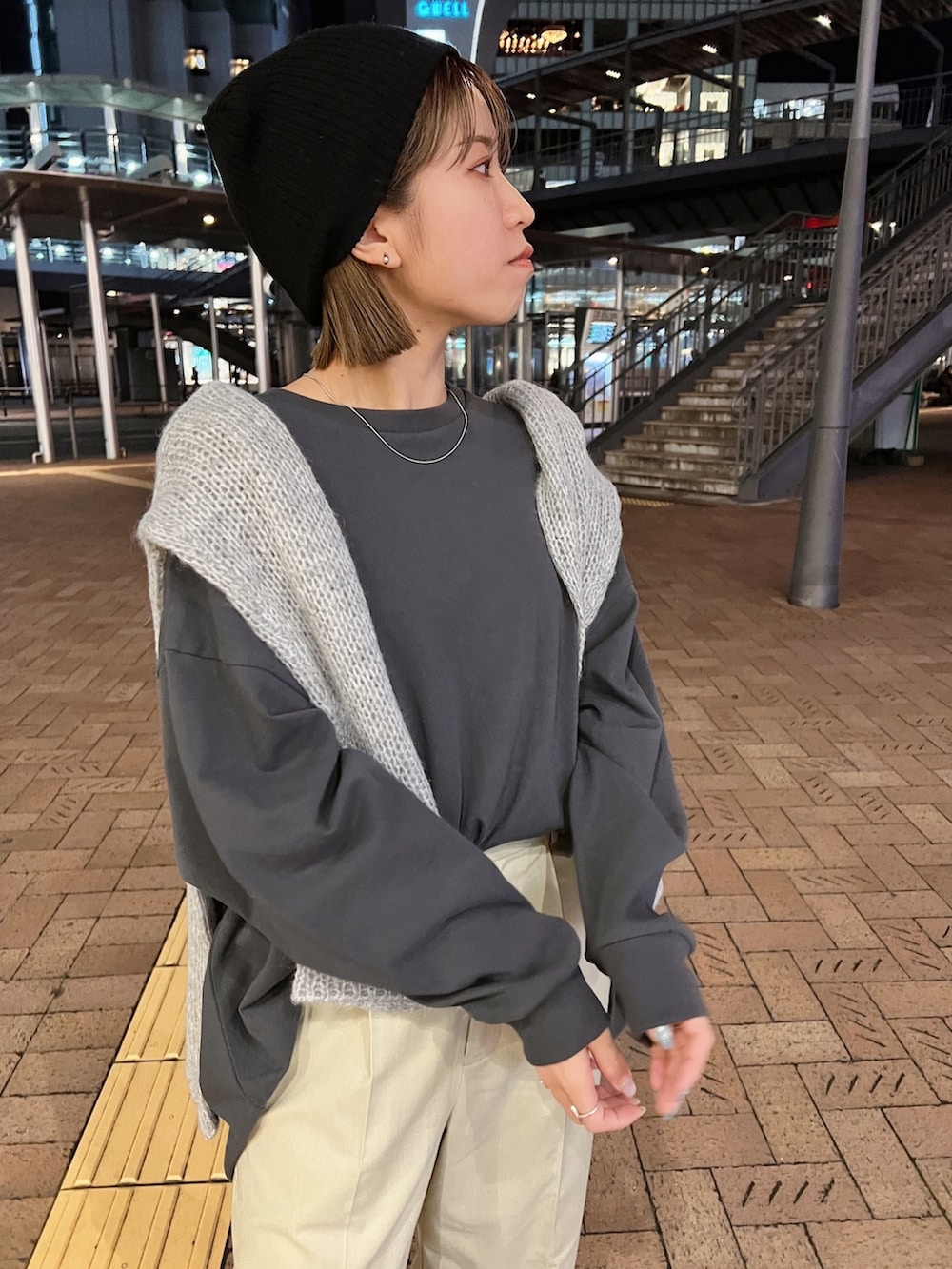 グレー系のTシャツ/カットソー、グレー系のニット/セーター、ベージュ系のスラックスを着用したレディースの冬コーディネートの6枚目の写真