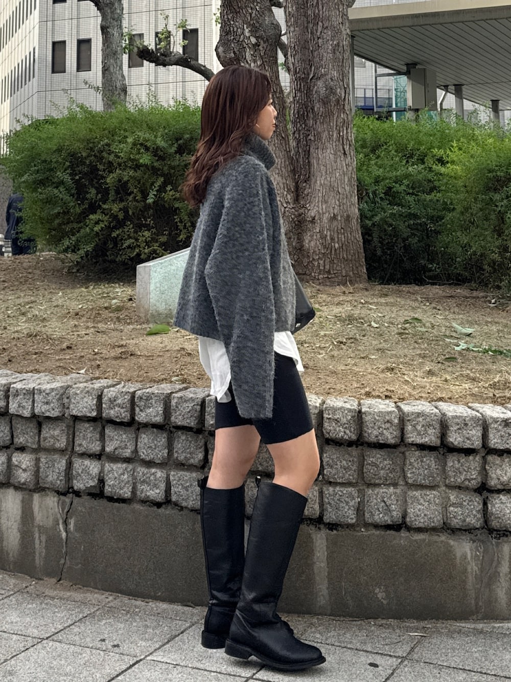 グレー系のニット/セーター、ホワイト系のTシャツ/カットソーを着用したレディースの秋コーディネートの2枚目の写真