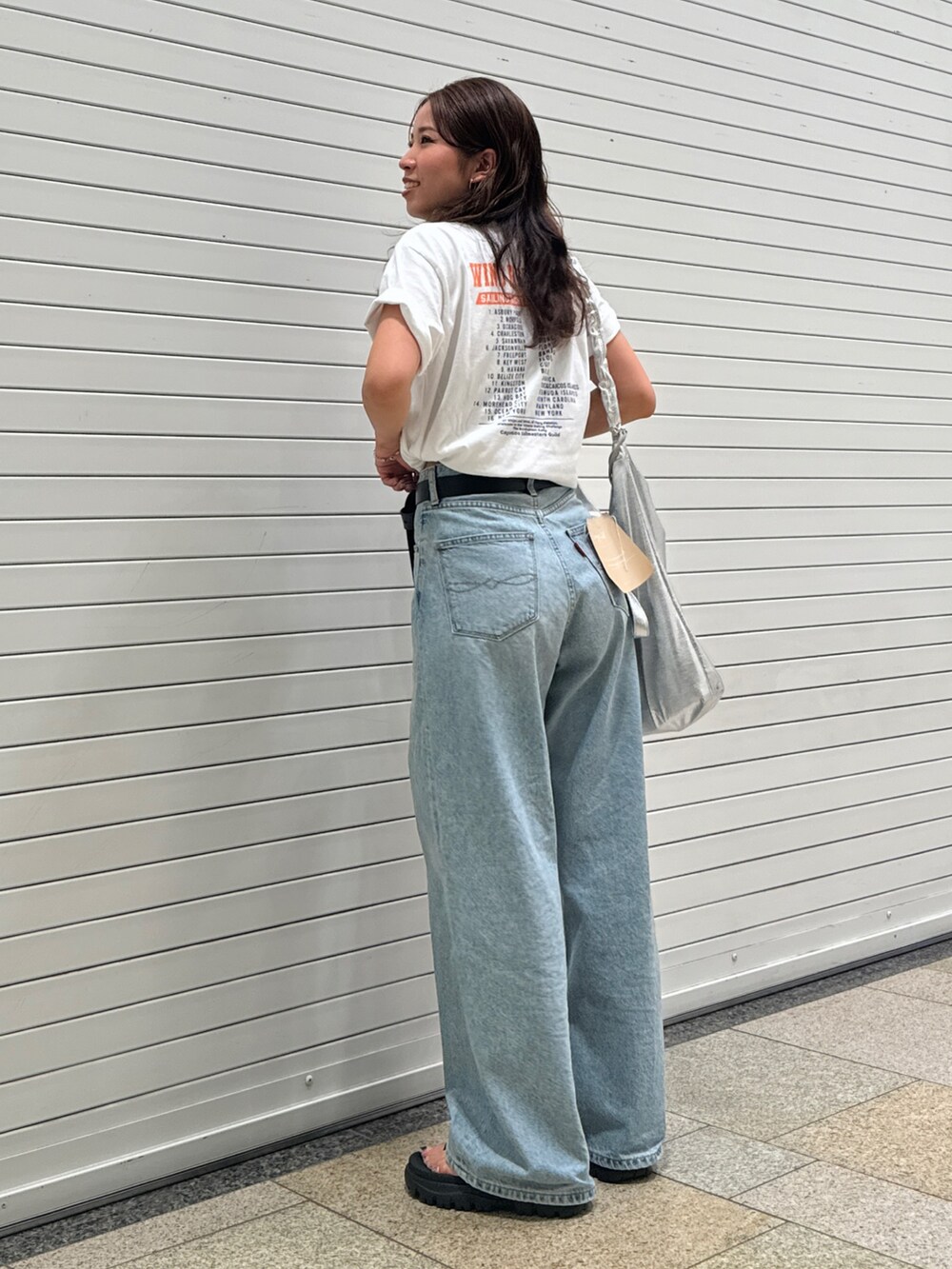 ブルー系のデニムパンツ、ホワイト系のTシャツ/カットソー、ブラック系のベルトを着用したレディースの夏コーディネートの2枚目の写真