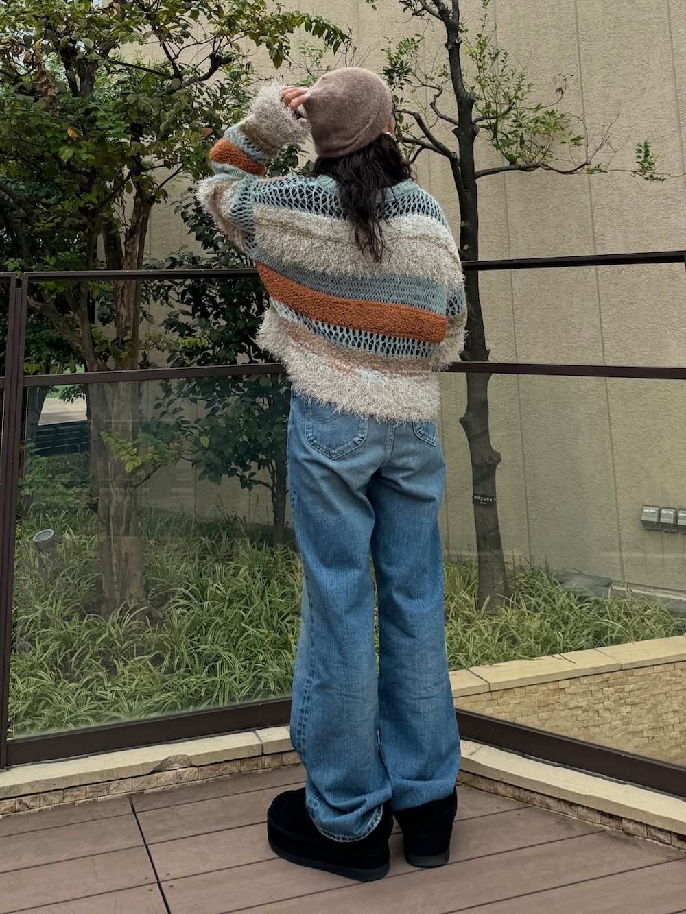 ブルー系のニット/セーター、ブラック系のTシャツ/カットソー、ブルー系のデニムパンツを着用したレディースの秋コーディネートの4枚目の写真