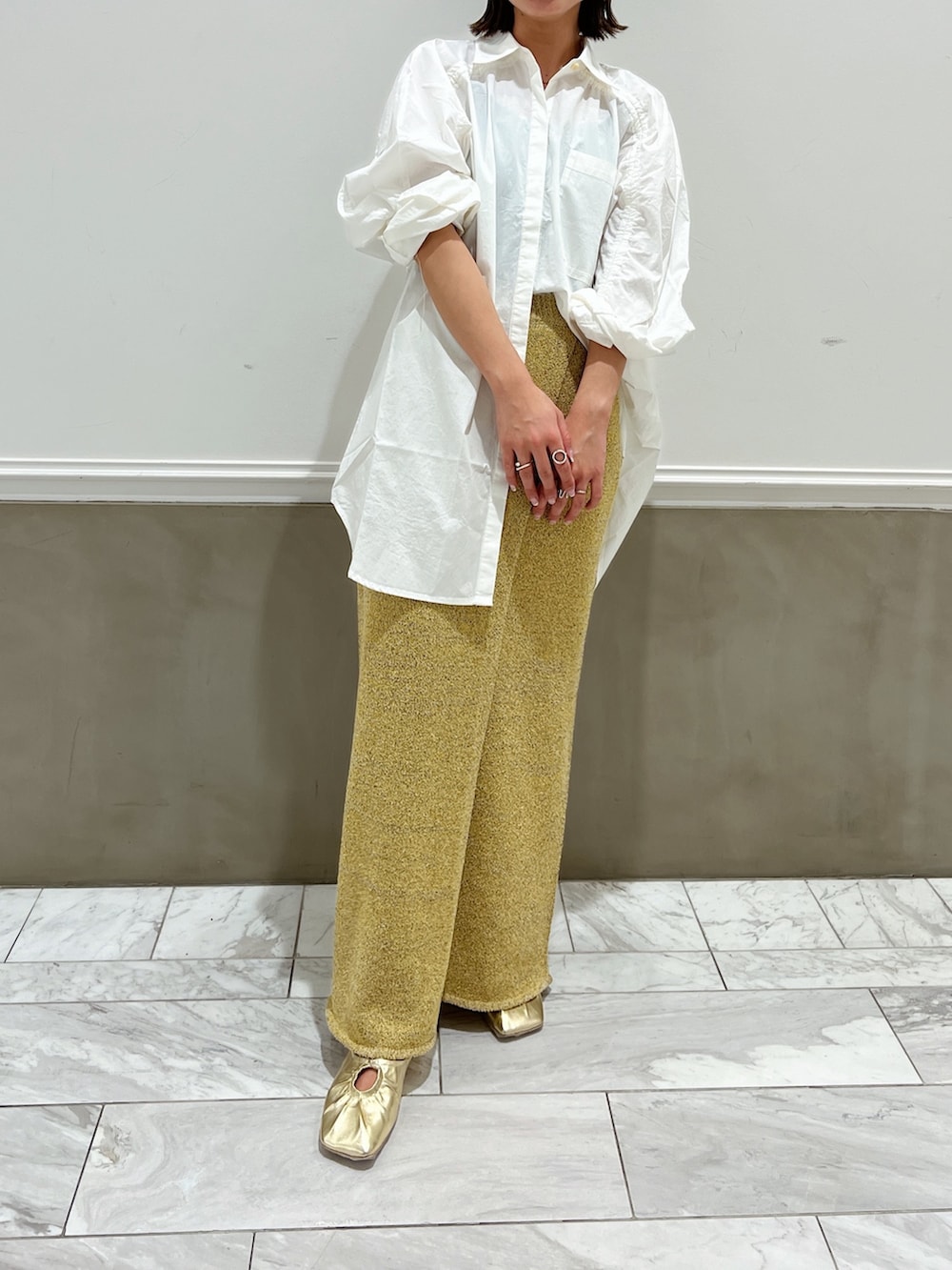 ホワイト系のシャツ/ブラウス、イエロー系のパンプス、ベージュ系のスカートを着用したレディースの冬コーディネートの2枚目の写真