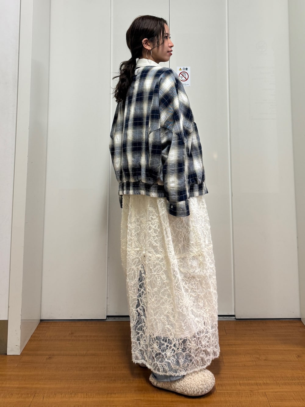 ベージュ系のブルゾン、ホワイト系のワンピース、ブルー系のデニムパンツを着用したレディースの冬コーディネートの4枚目の写真