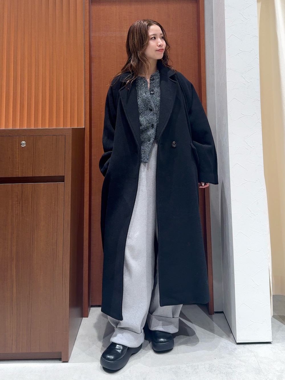 グレー系のカーディガン/ボレロ、グレー系のその他パンツ、ブラック系のチェスターコートを着用したレディースの冬コーディネートの5枚目の写真