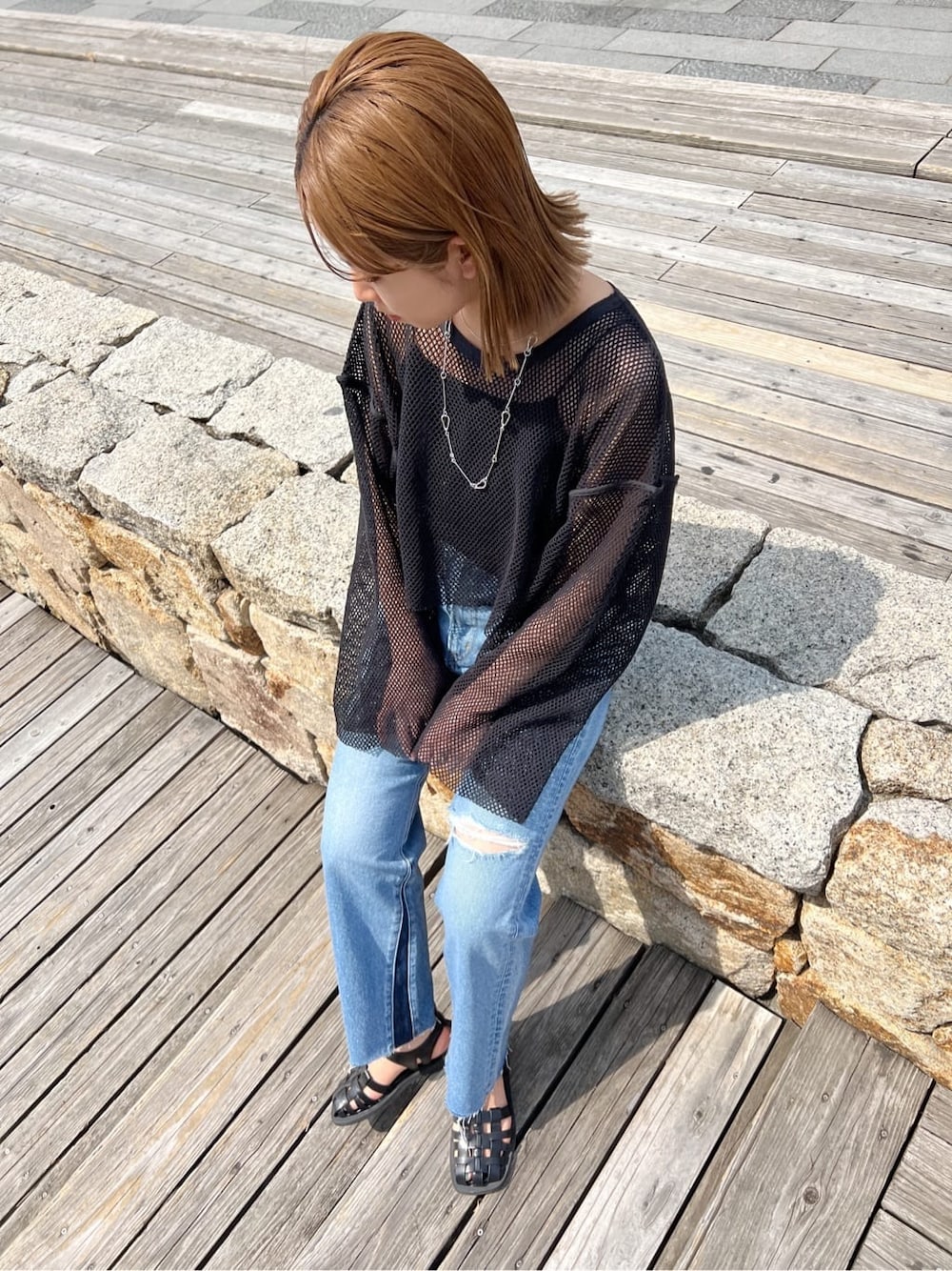 ブラック系のサンダル、ブルー系のデニムパンツ、ブラック系のTシャツ/カットソーを着用したレディースの春コーディネートの2枚目の写真