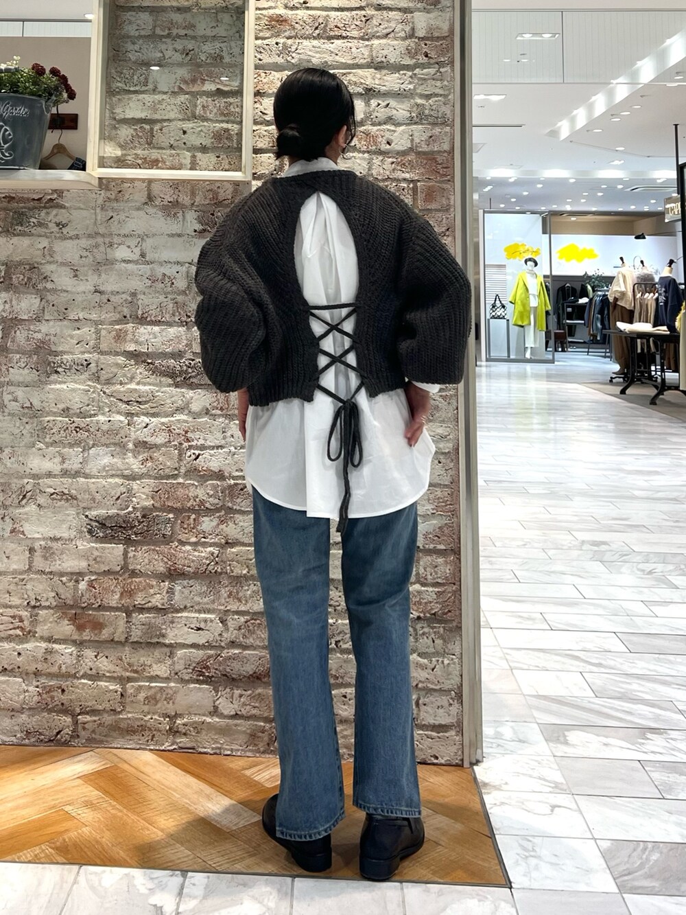 グレー系のニット/セーター、ブルー系のデニムパンツ、ブラック系のローファーを着用したレディースの秋コーディネートの8枚目の写真