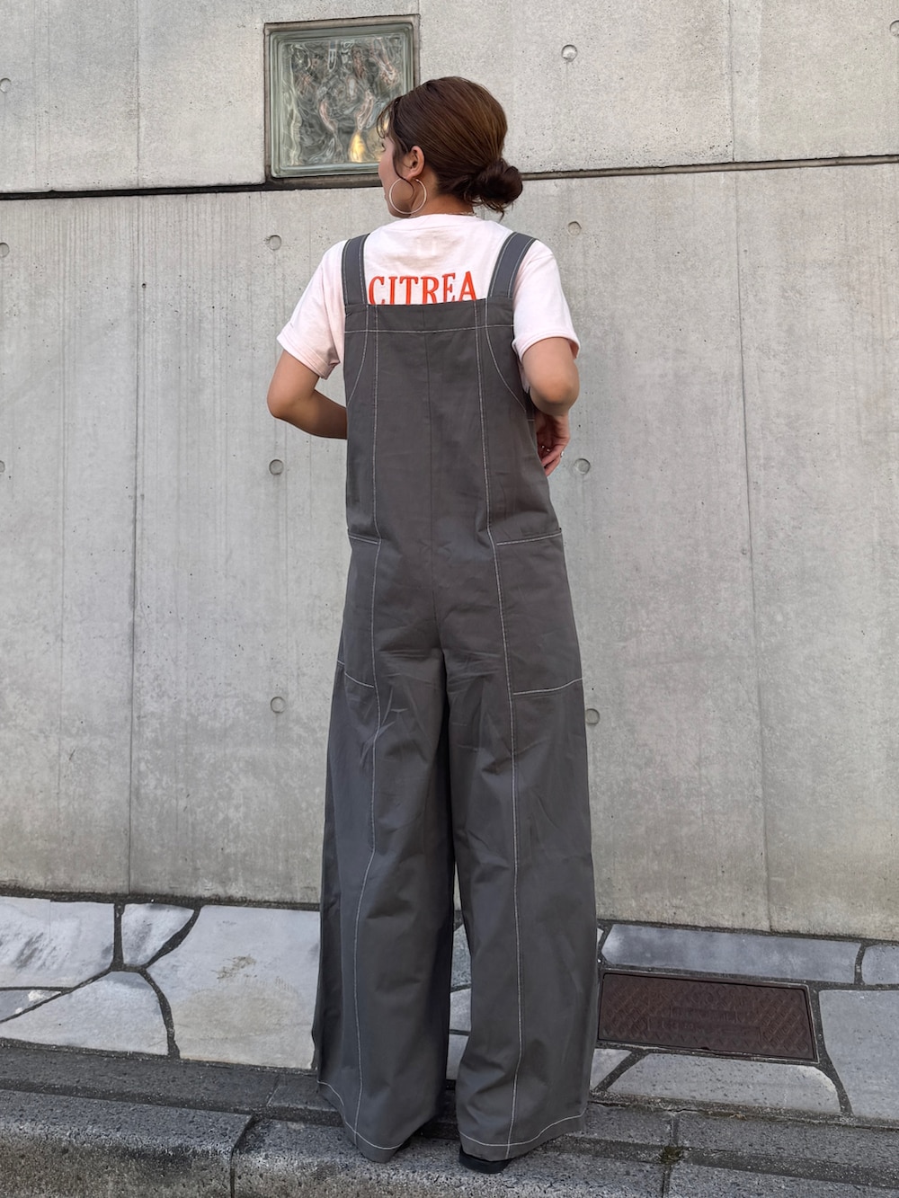 ピンク系のTシャツ/カットソー、ブラック系のサロペット/オーバーオール、ブラック系のサンダルを着用したレディースの春コーディネートの4枚目の写真