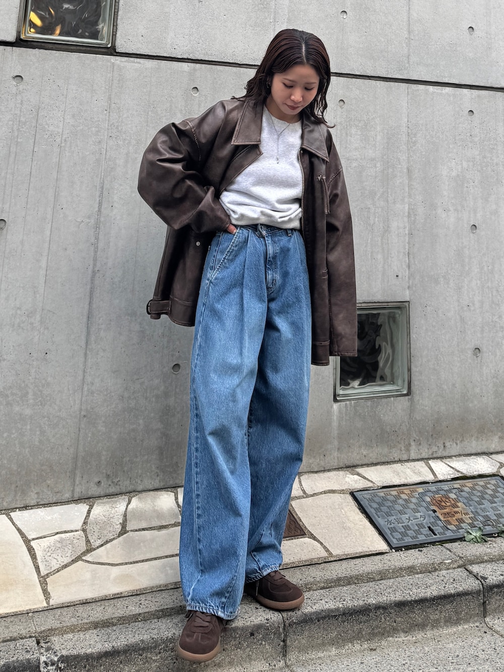 ブルー系のデニムパンツ、グレー系のスウェット、ブラウン系のブルゾンを着用したレディースの秋コーディネートの2枚目の写真