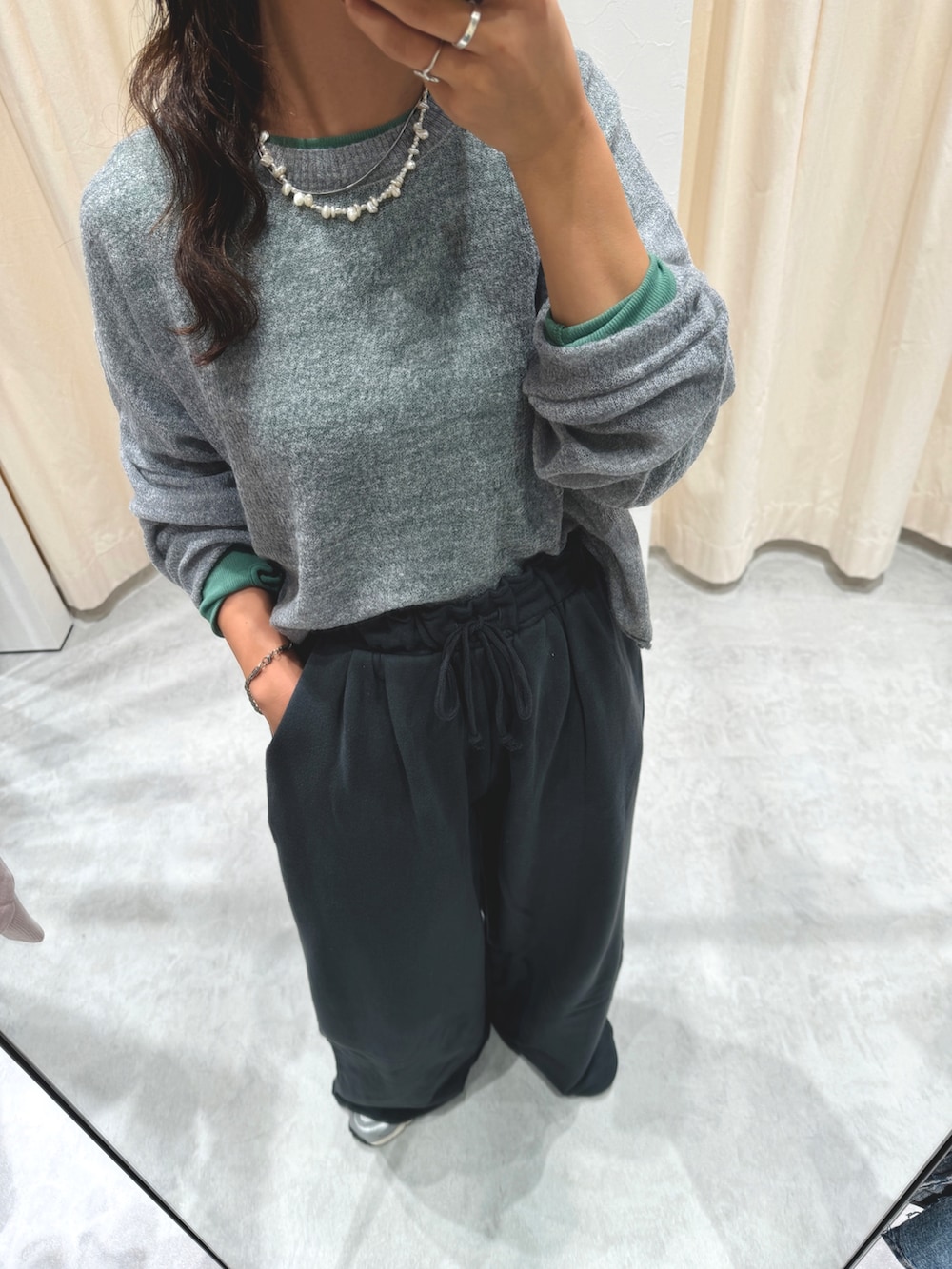 グレー系のニット/セーター、グリーン系のTシャツ/カットソー、グレー系のスウェットパンツを着用したレディースの秋コーディネートの8枚目の写真