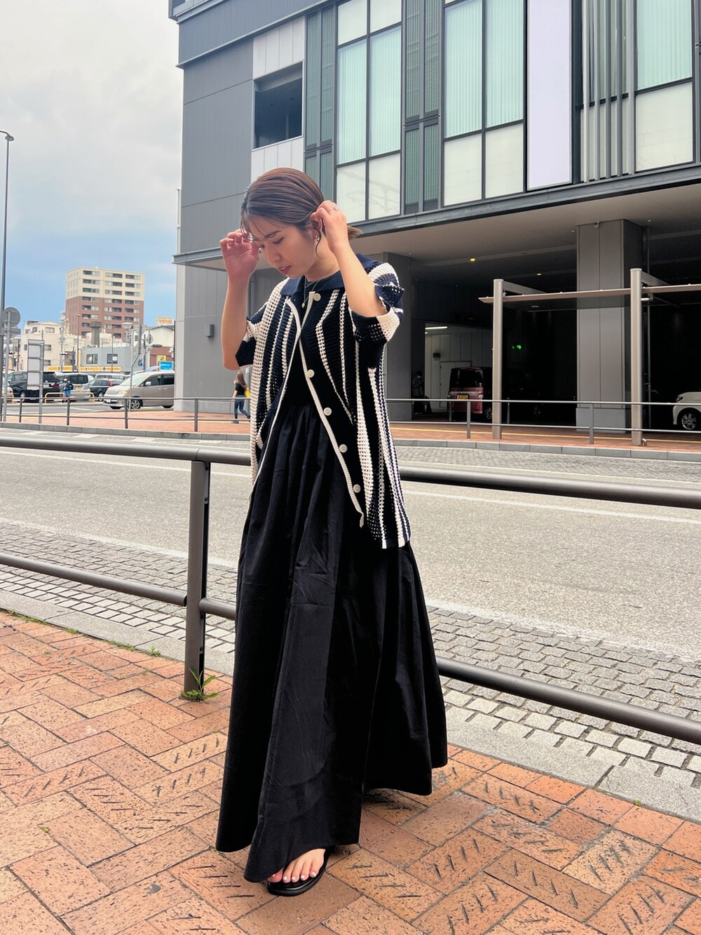 ブラック系のワンピース、ブルー系のカーディガン/ボレロ、ブラック系のサンダルを着用したレディースの春コーディネートの3枚目の写真