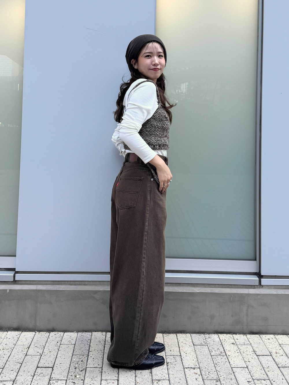 ブラウン系のデニムパンツ、ブラウン系のキャミソール、ホワイト系のTシャツ/カットソーを着用したレディースの秋コーディネートの3枚目の写真