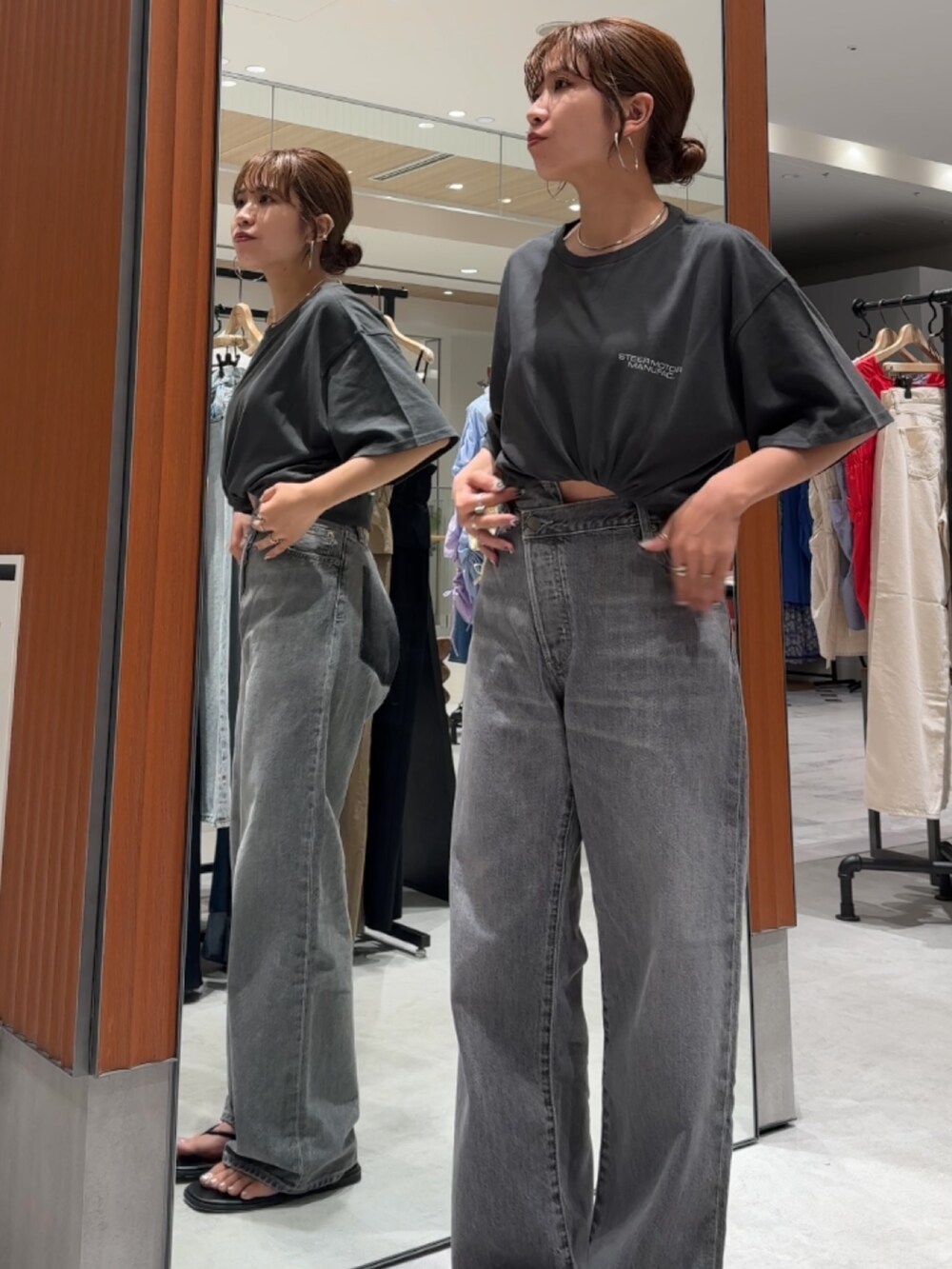 ブラック系のデニムパンツ、グレー系のTシャツ/カットソー、ブラック系のサンダルを着用したレディースの夏コーディネートの2枚目の写真