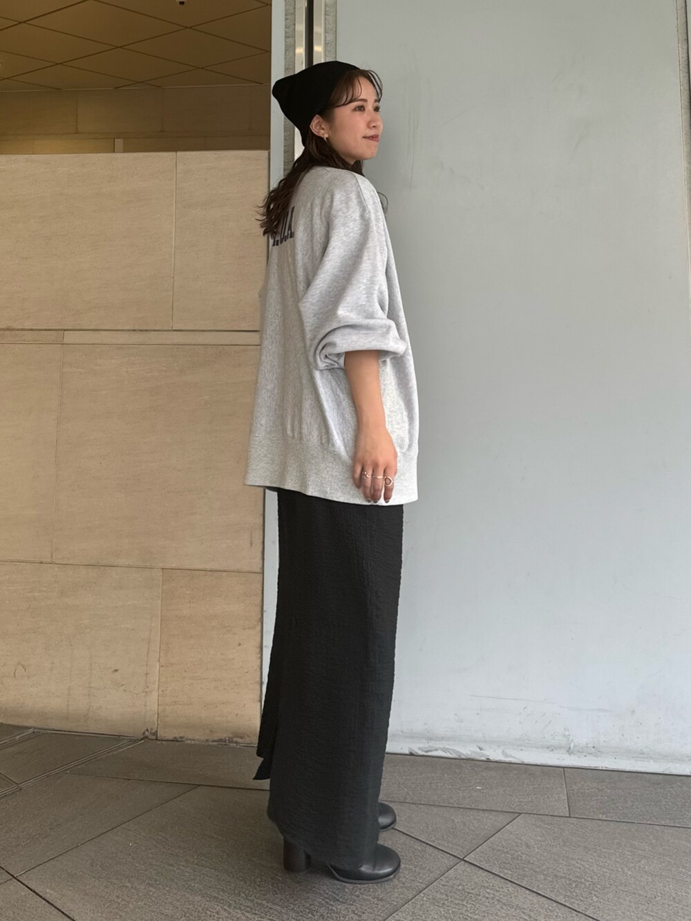 グレー系のスウェット、ブラック系のスカート、ブラック系のニットキャップ/ビーニーを着用したレディースの夏コーディネートの3枚目の写真