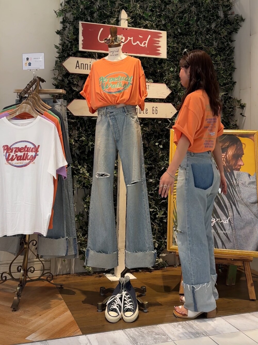 ブルー系のデニムパンツ、オレンジ系のTシャツ/カットソー、ホワイト系のサンダルを着用したレディースの夏コーディネートの2枚目の写真