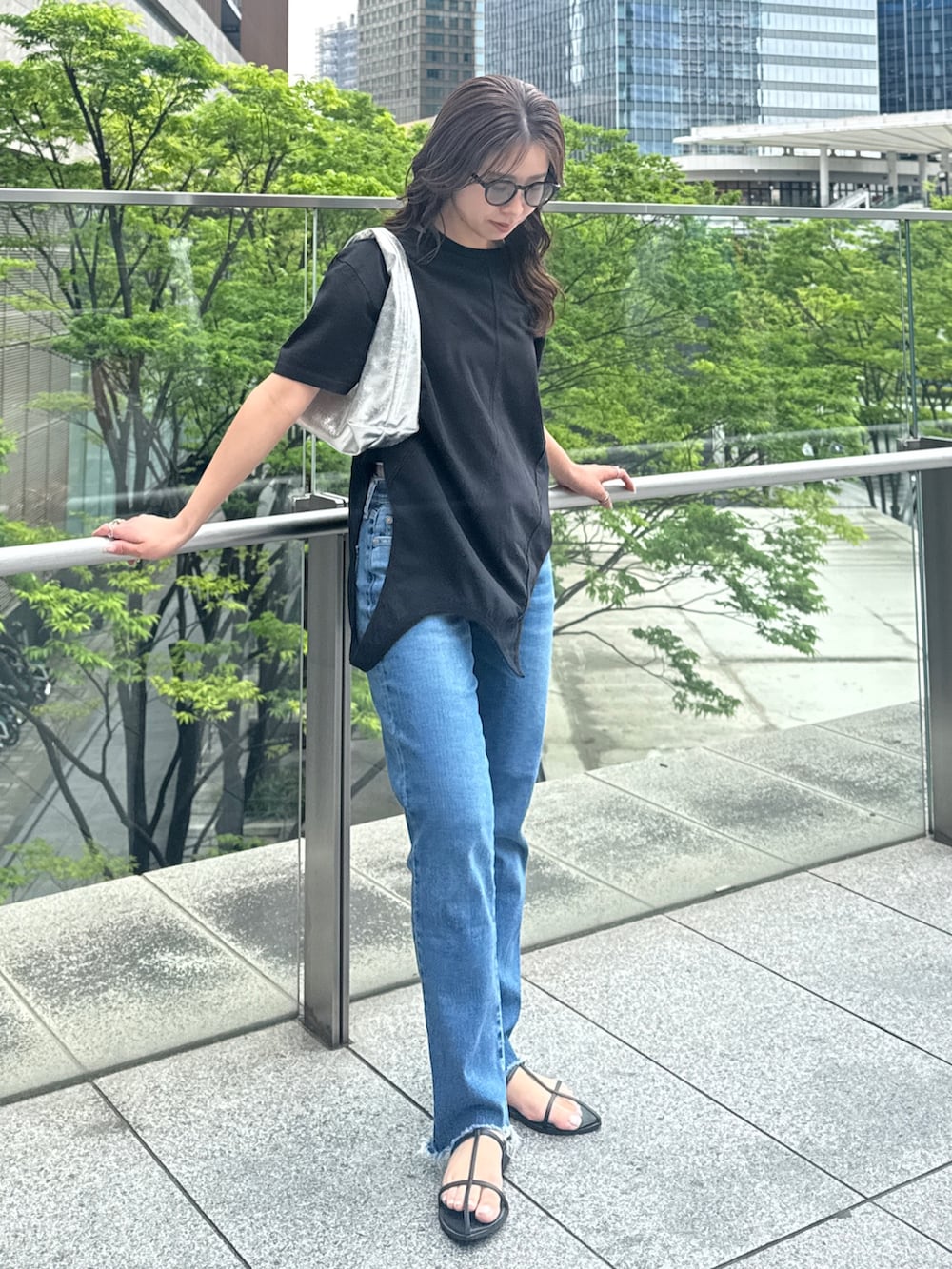 ブラック系のTシャツ/カットソー、ブルー系のデニムパンツを着用したレディースの春コーディネートの7枚目の写真