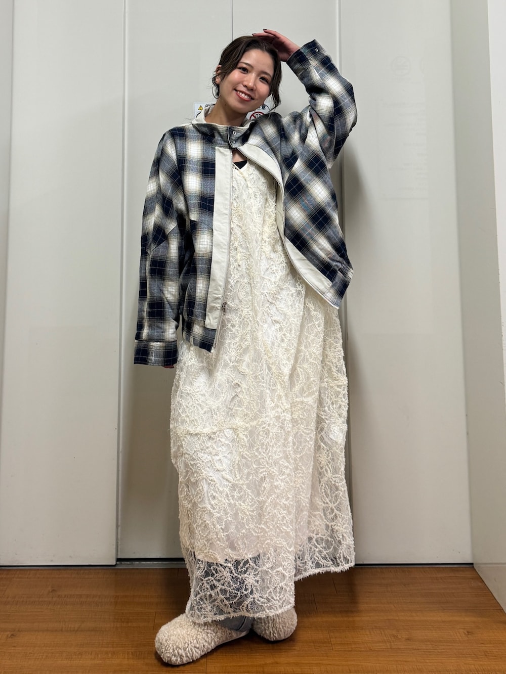 ベージュ系のブルゾン、ホワイト系のワンピース、ブルー系のデニムパンツを着用したレディースの冬コーディネートの3枚目の写真