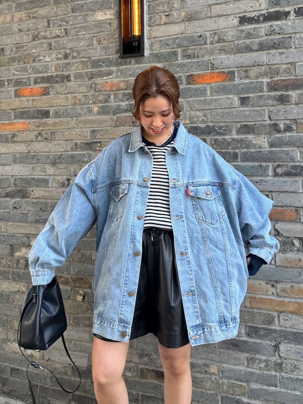 ブルー系のデニムジャケット、ブルー系のTシャツ/カットソー、ブラック系のその他パンツを着用したレディースの冬コーディネートの9枚目の写真