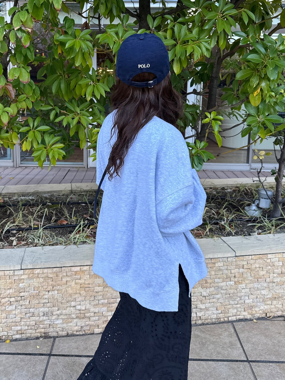 ブラック系のスカート、グレー系のスウェット、ブラック系のスニーカーを着用したレディースの冬コーディネートの6枚目の写真