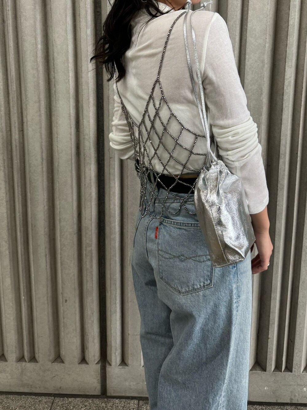 ブラック系のベスト、ブルー系のデニムパンツ、ホワイト系のTシャツ/カットソーを着用したレディースの冬コーディネートの7枚目の写真