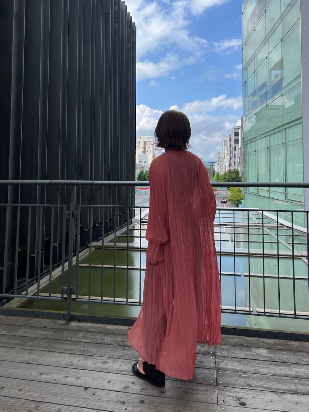 ブラック系のタンクトップ、ピンク系のワンピース、グレー系のスラックスを着用したレディースの夏コーディネートの3枚目の写真