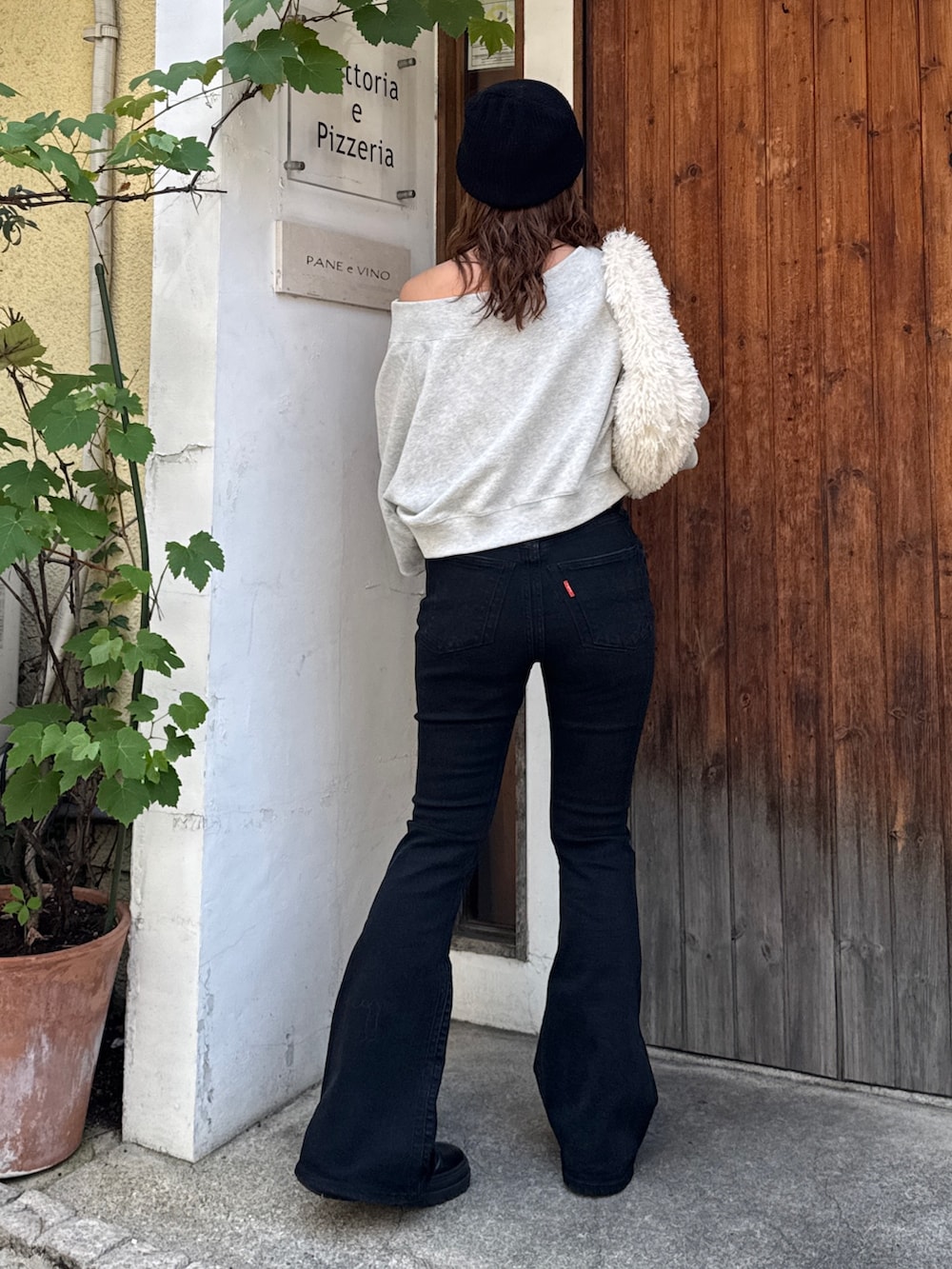 ブラック系のデニムパンツ、グレー系のスウェット、ホワイト系のハンドバッグを着用したレディースの夏コーディネートの5枚目の写真