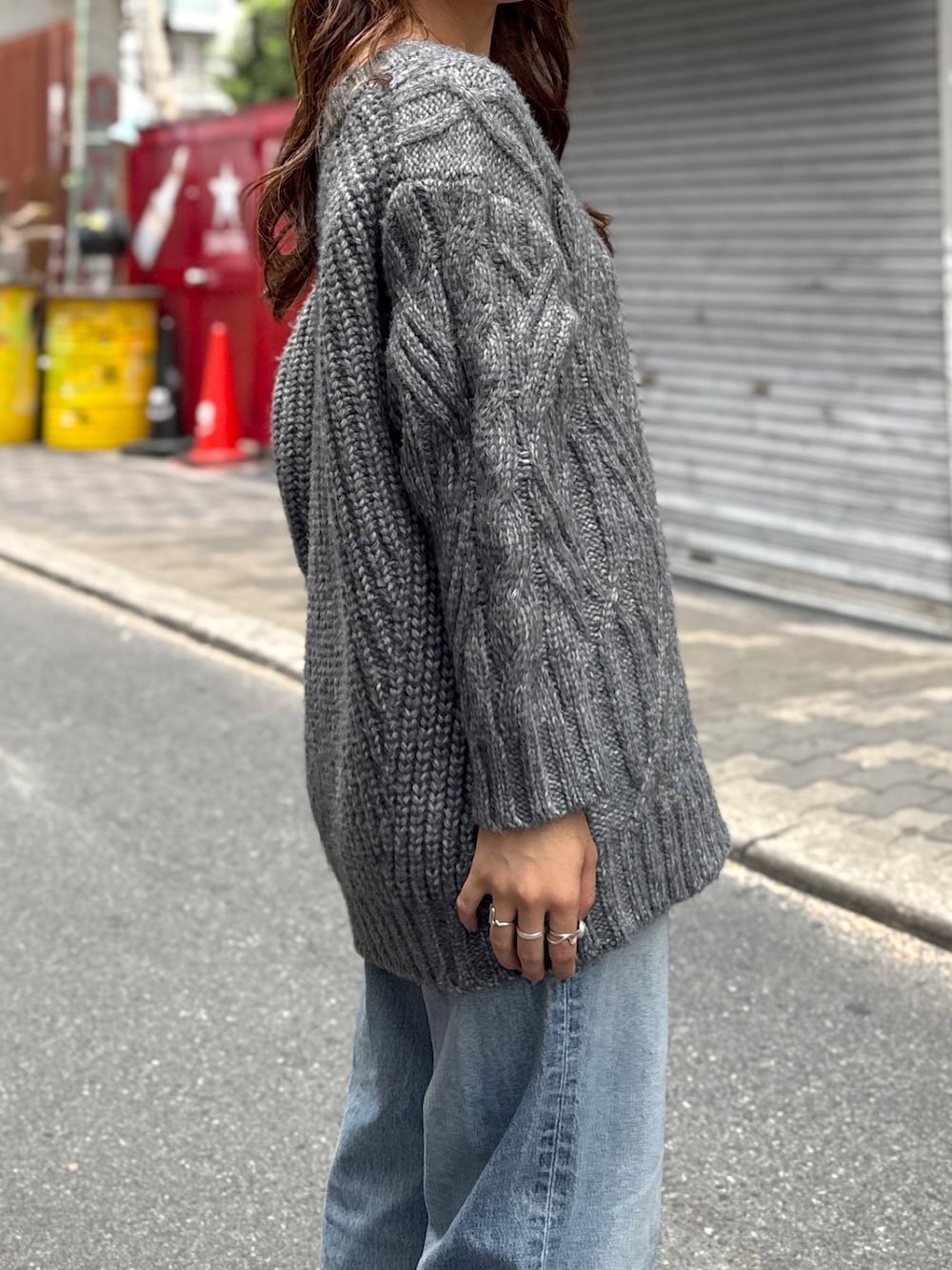 グレー系のニット/セーター、ブルー系のデニムパンツ、ブラック系のサンダルを着用したレディースの秋コーディネートの6枚目の写真