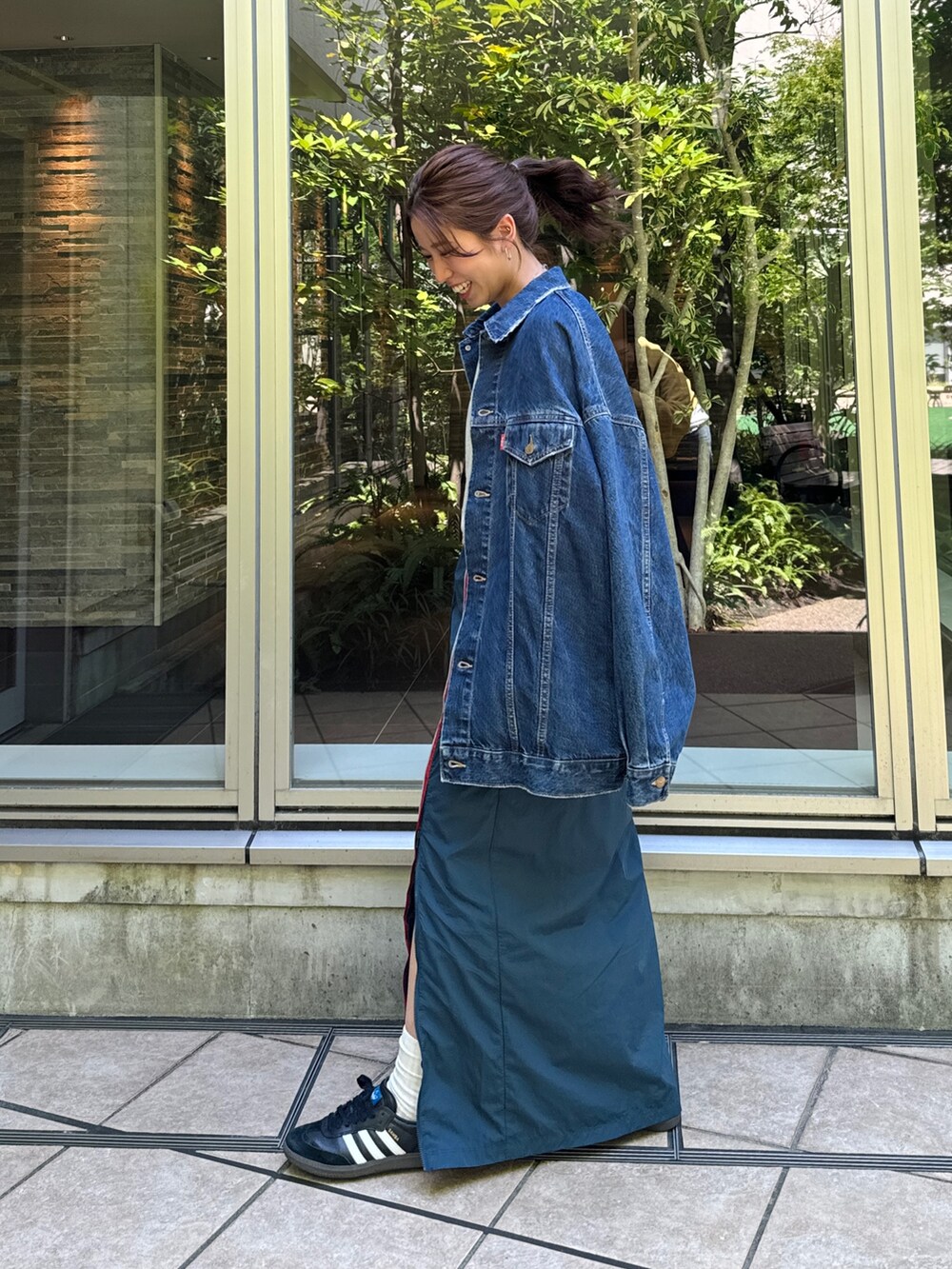 ブルー系のスカート、グレー系のスウェット、ブルー系のデニムジャケットを着用したレディースの夏コーディネートの4枚目の写真