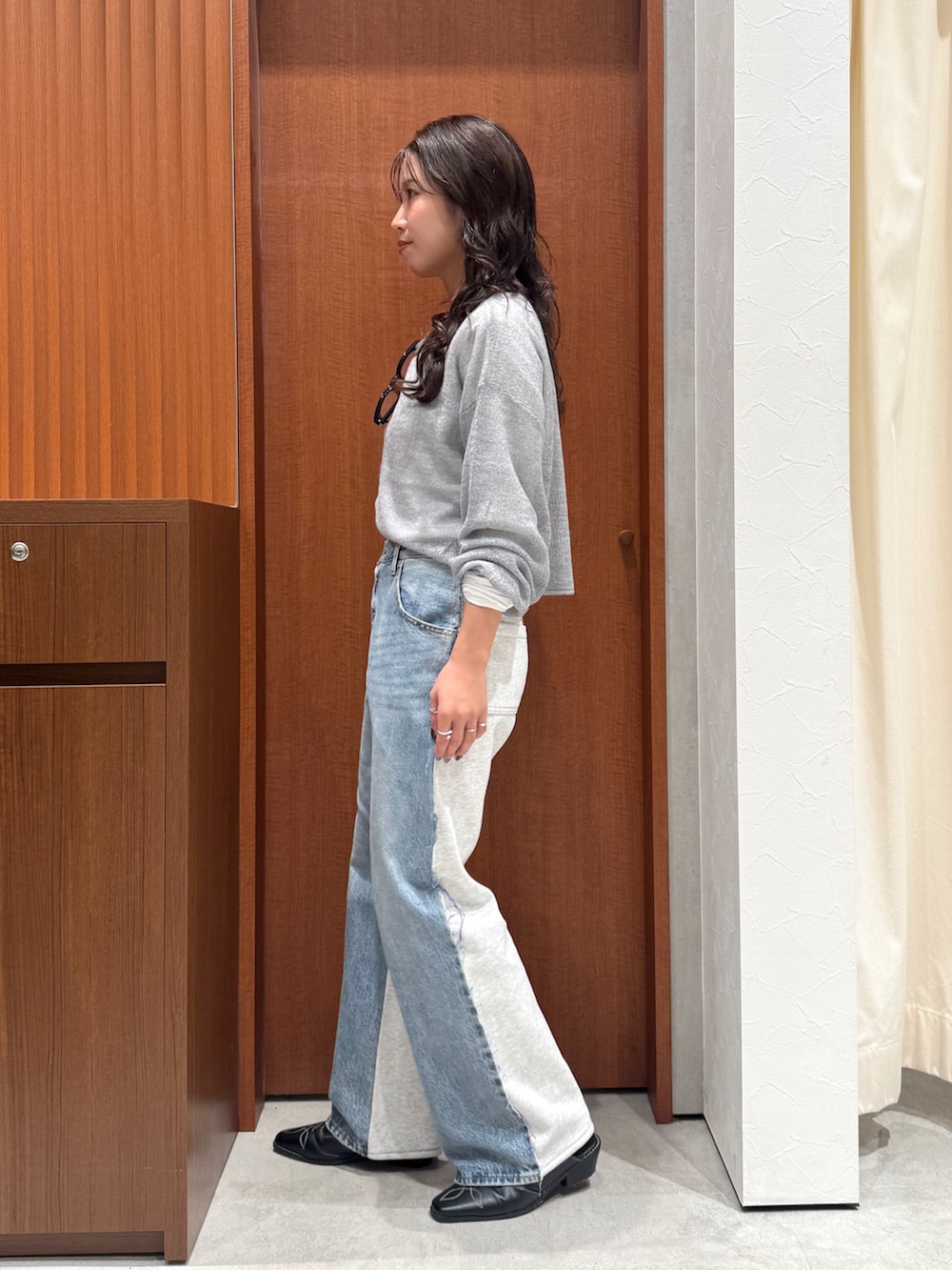 ブルー系のデニムパンツ、グレー系のニット/セーター、ホワイト系のTシャツ/カットソーを着用したレディースの秋コーディネートの4枚目の写真