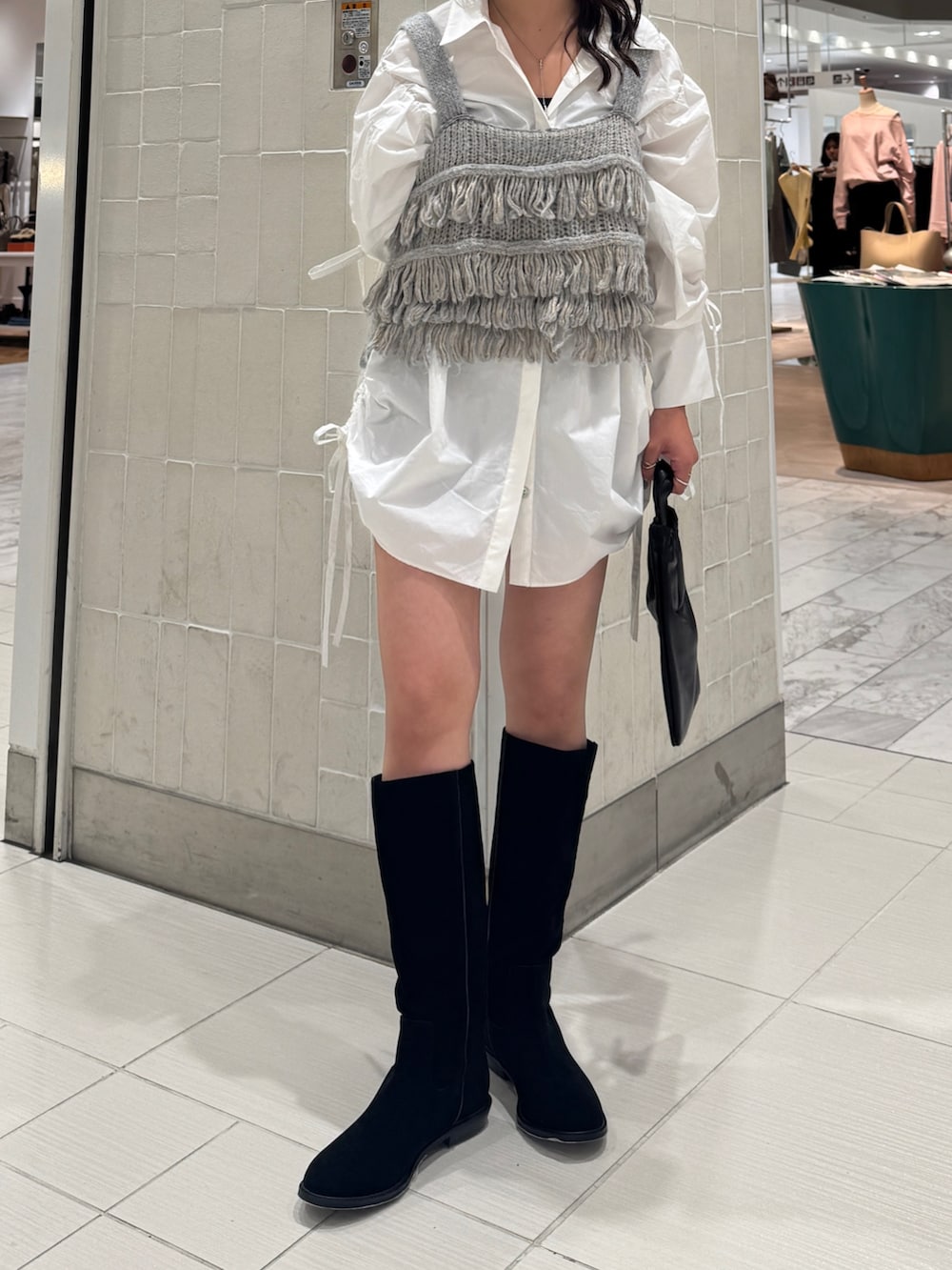 ホワイト系のシャツ/ブラウス、ブルー系のニット/セーター、ブラック系のショルダーバッグを着用したレディースの秋コーディネートの2枚目の写真