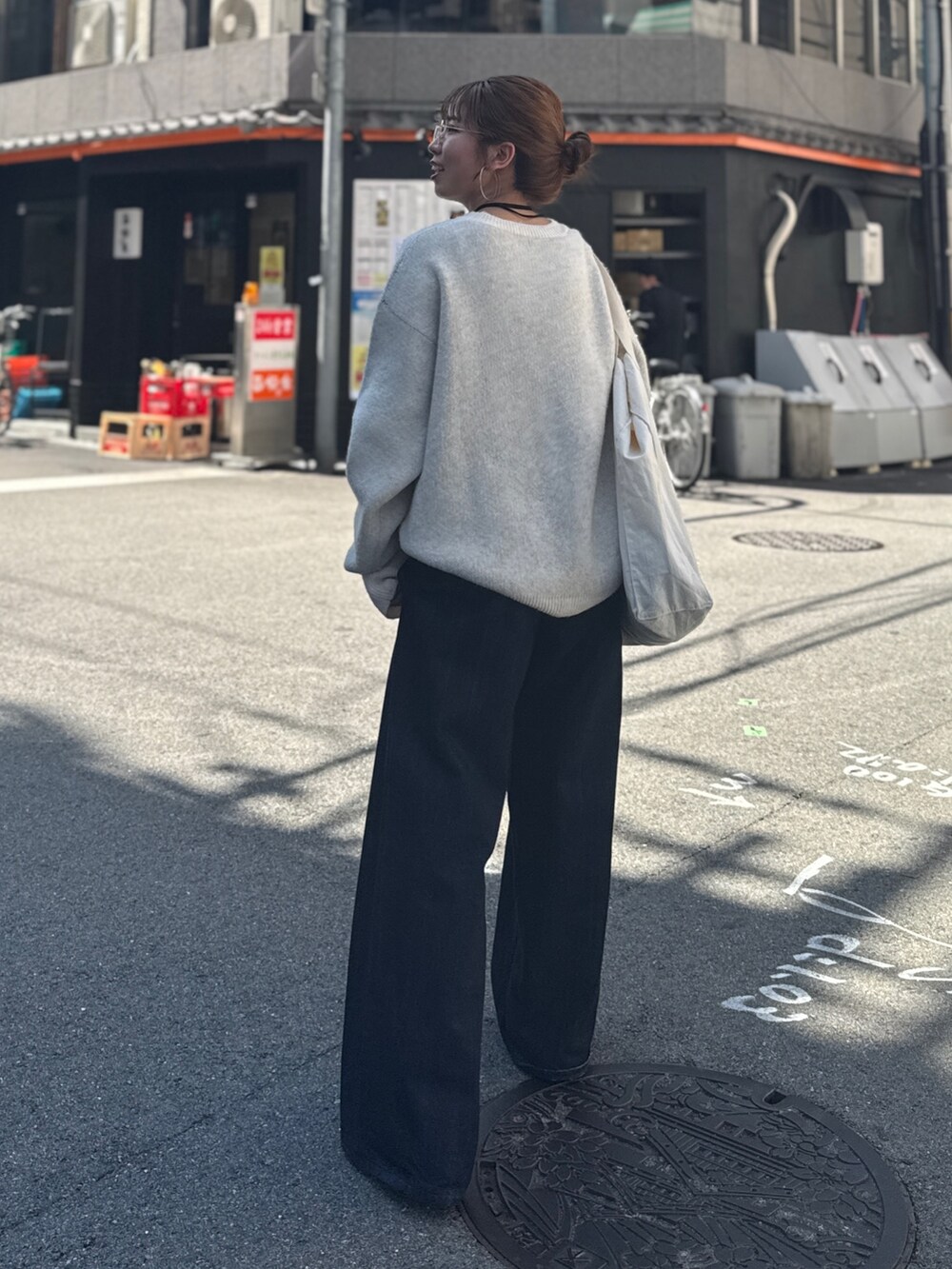 ブルー系のデニムパンツ、ホワイト系のニット/セーター、ホワイト系のトートバッグを着用したレディースの夏コーディネートの7枚目の写真