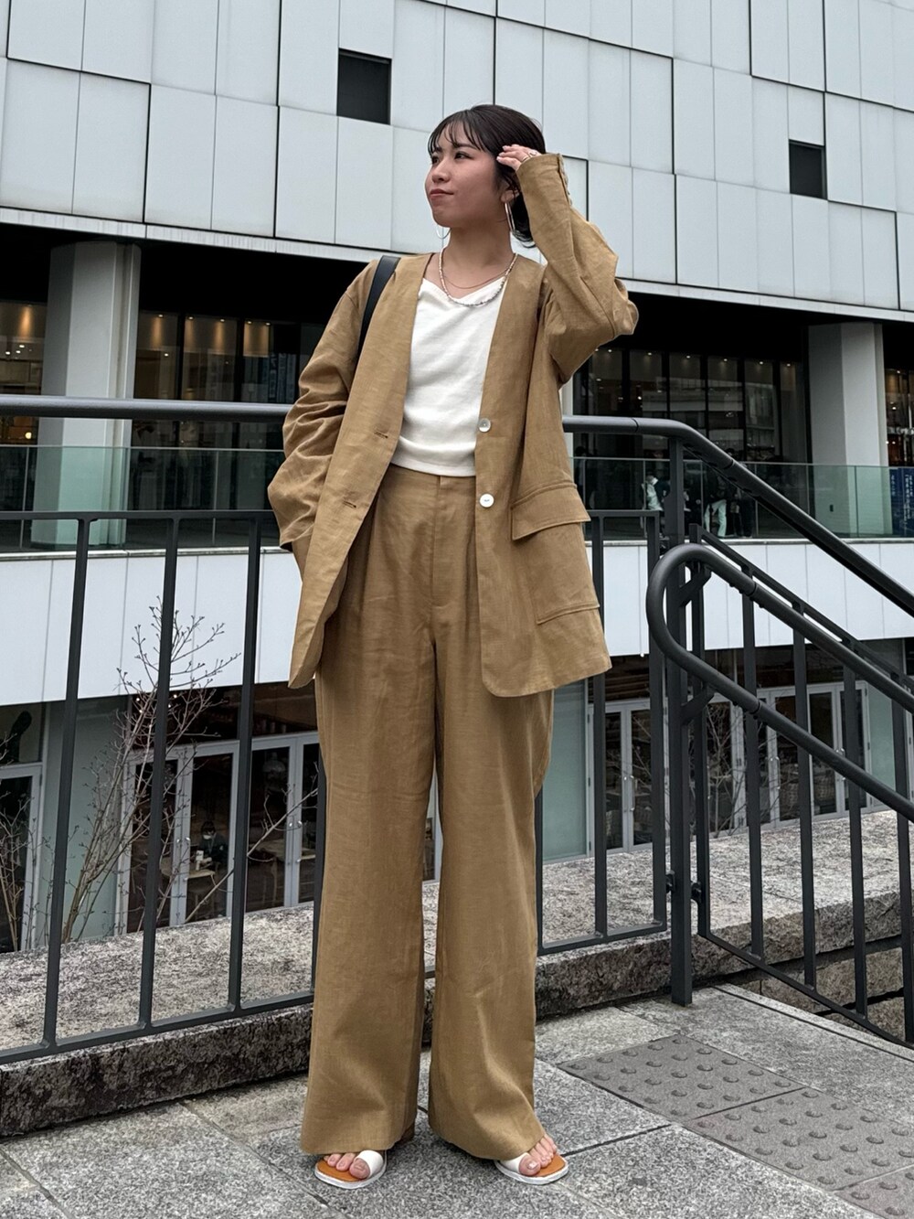 ベージュ系のテーラードジャケット、ベージュ系のその他パンツ、ホワイト系のTシャツ/カットソーを着用したレディースの春コーディネートの3枚目の写真