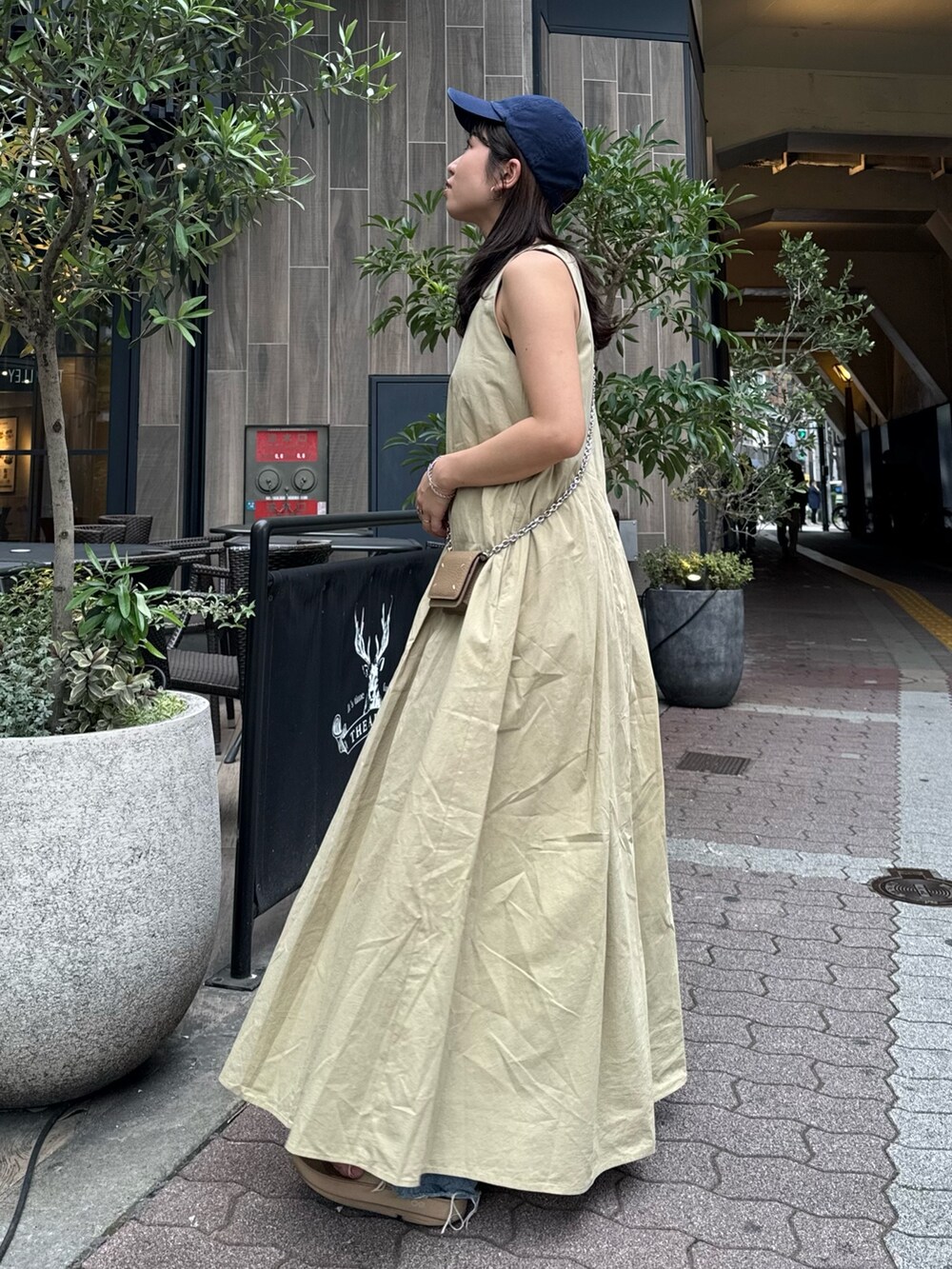 ベージュ系のワンピース、ブルー系のデニムパンツを着用したレディースの春コーディネートの5枚目の写真