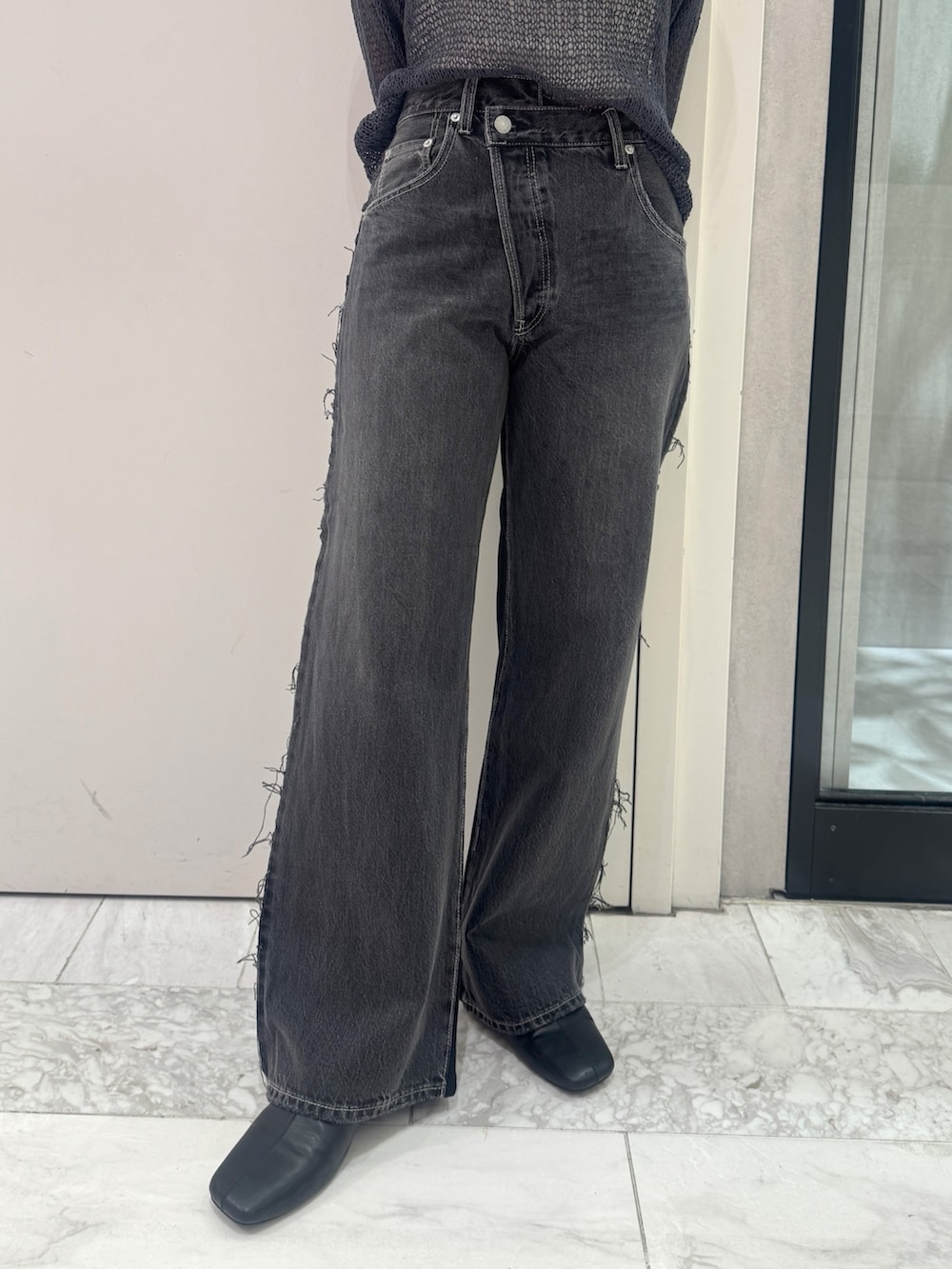 ブラック系のデニムパンツ、グレー系のニット/セーター、ブラック系のサンダルを着用したレディースの秋コーディネートの8枚目の写真