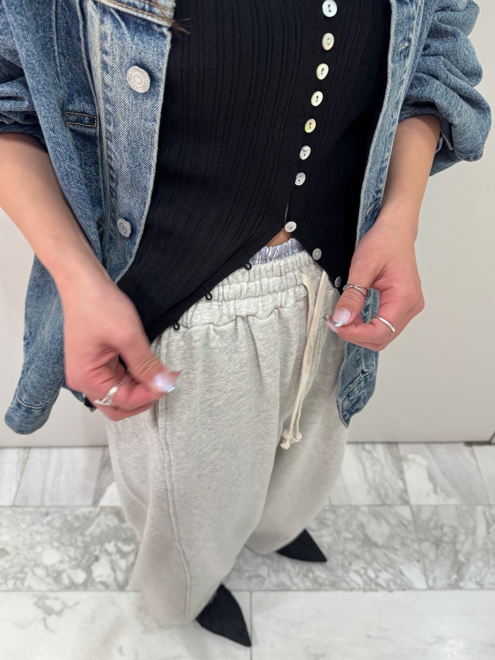 ブルー系のデニムジャケット、ブラック系のカーディガン/ボレロ、ホワイト系のスウェットパンツを着用したレディースの冬コーディネートの7枚目の写真