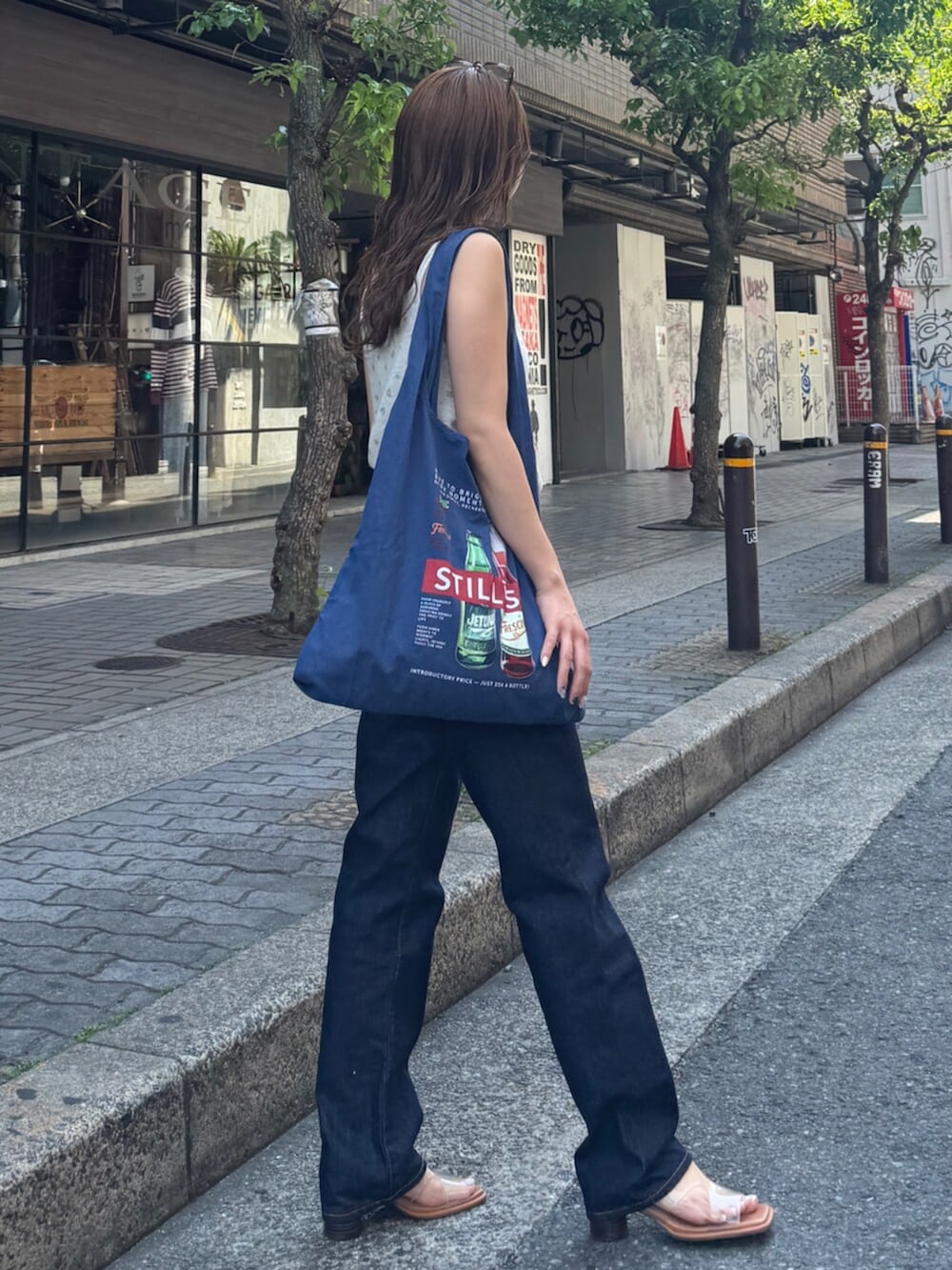 ブルー系のデニムパンツ、その他のサンダル、ブルー系のトートバッグを着用したレディースの春コーディネートの5枚目の写真