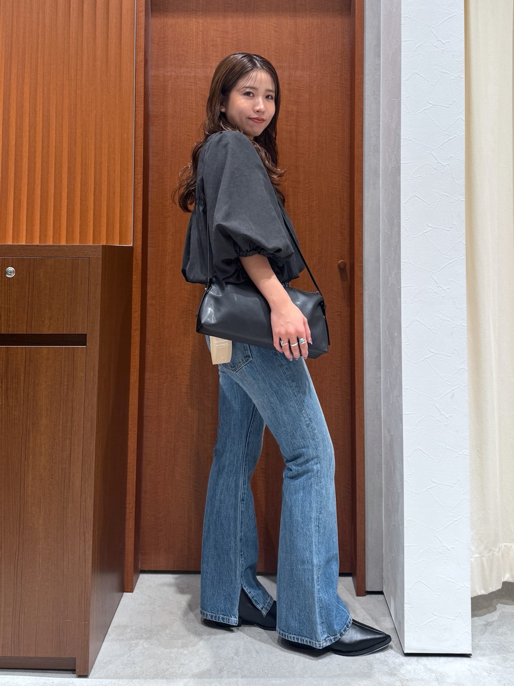 ブルー系のデニムパンツ、ブラウン系のシャツ/ブラウス、ブラック系のハンドバッグを着用したレディースの夏コーディネートの3枚目の写真
